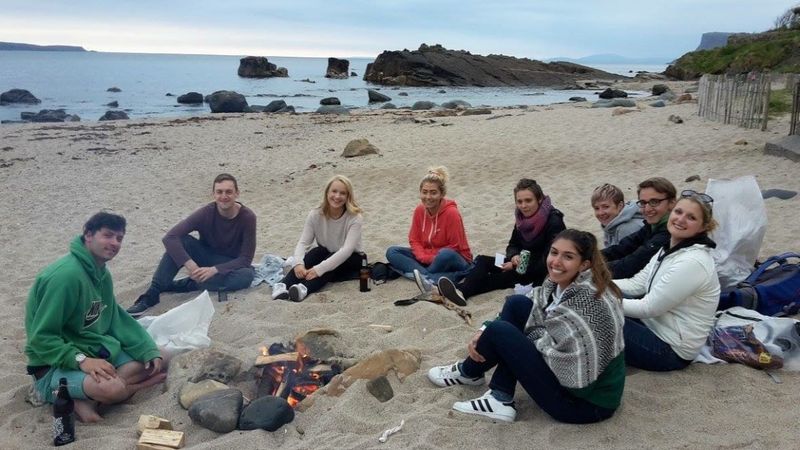 Seeds of Hope participants gathered around a beach bonfire at Corrymeela