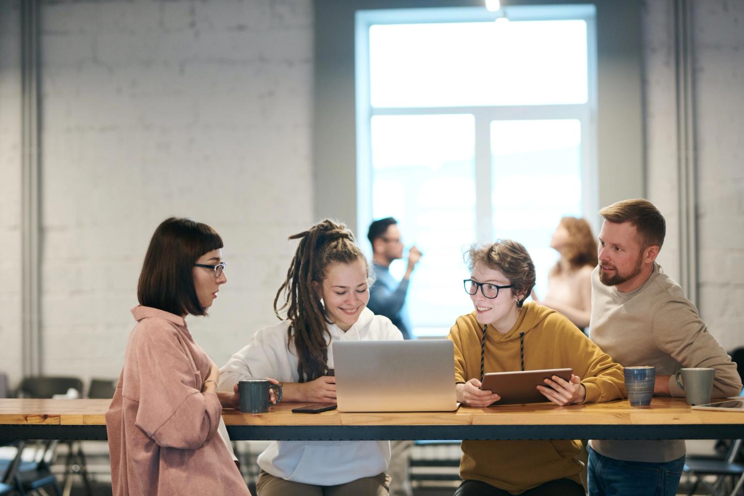 Gruppe unge voksne mennesker, en skriver på en mac/PC