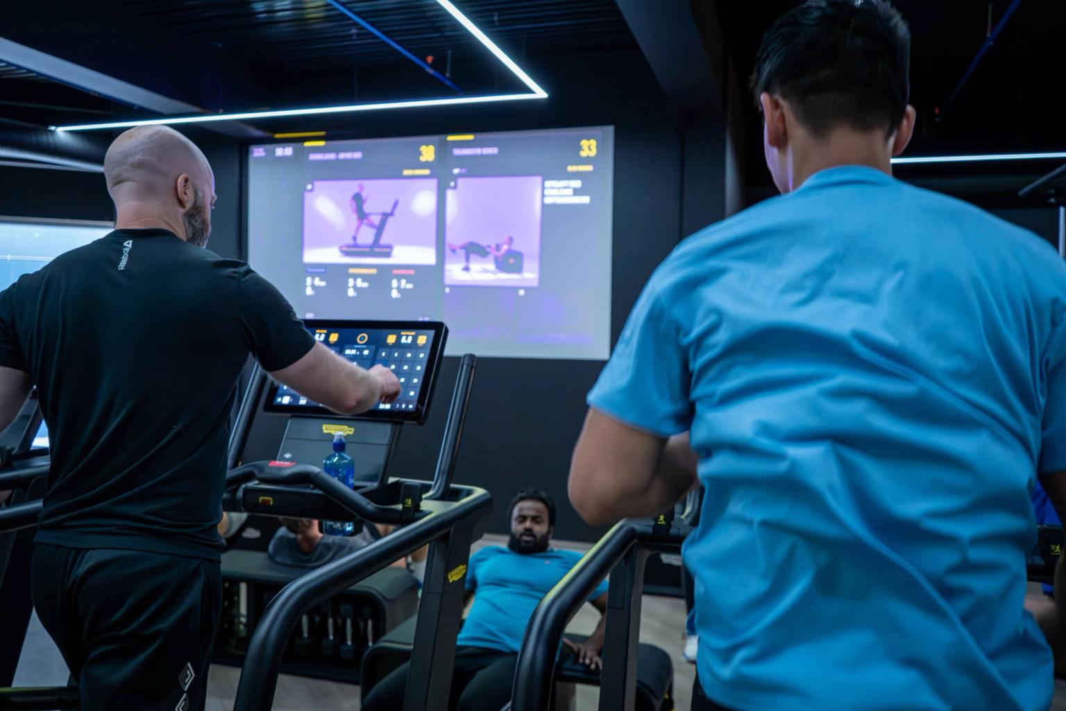 Men jogging on treadmills at the gym.