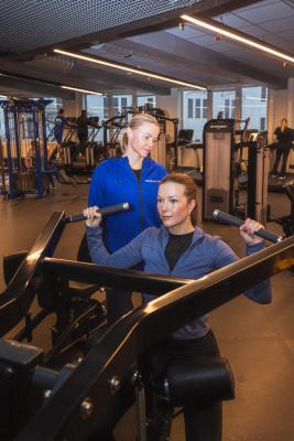 En dame og personlig trener, som trener styrke på Sammen sitt treningssenter