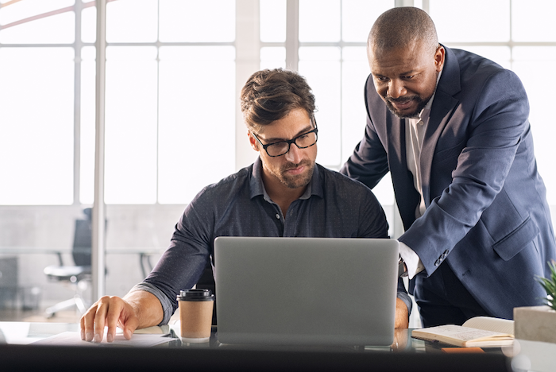 Business coach discussing actionable strategies while a mentor provides long-term career guidance during a collaborative session.