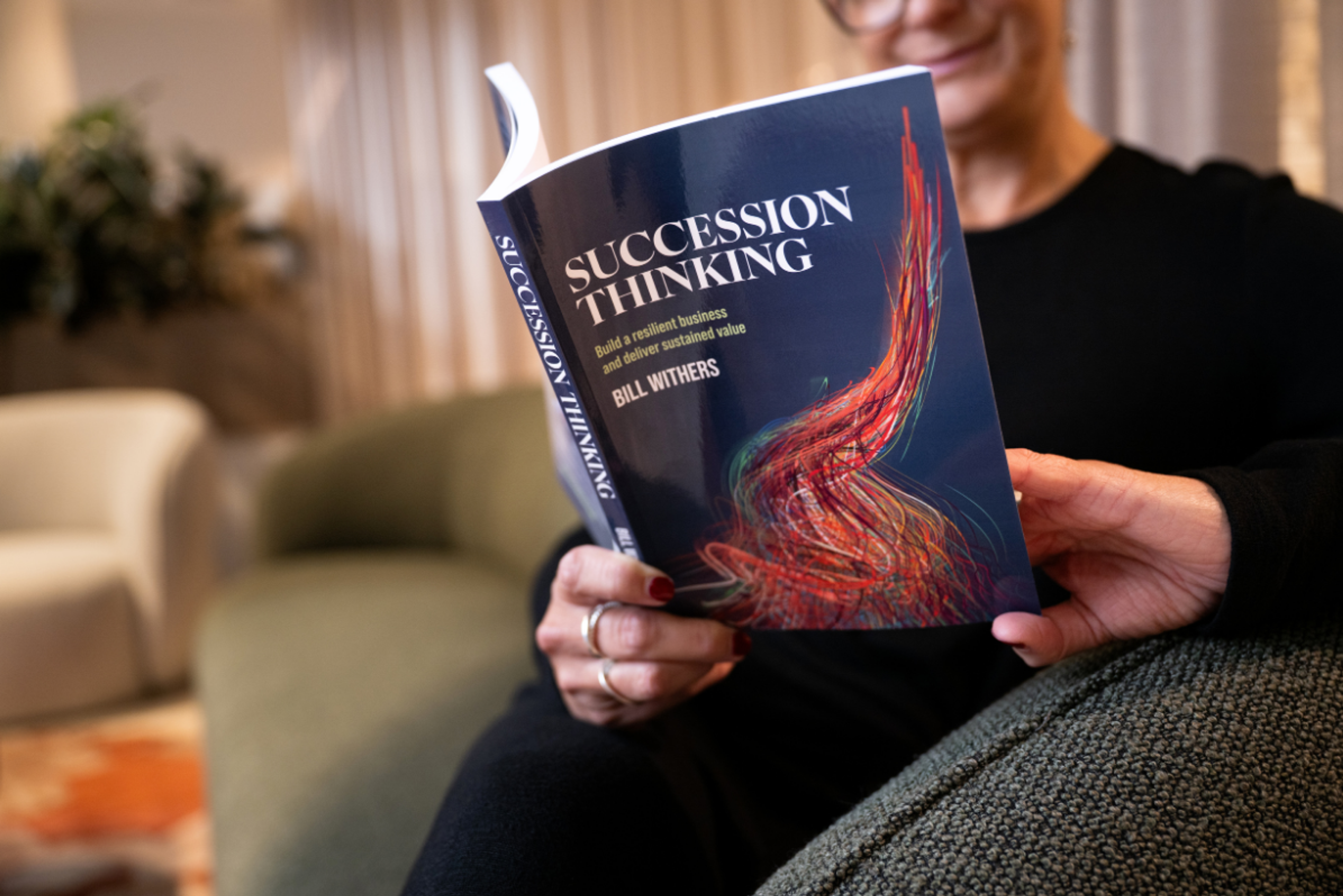 A business owner reading a book called Succession Thinking™ to learn how to proactively prepare to handover or sell her business 