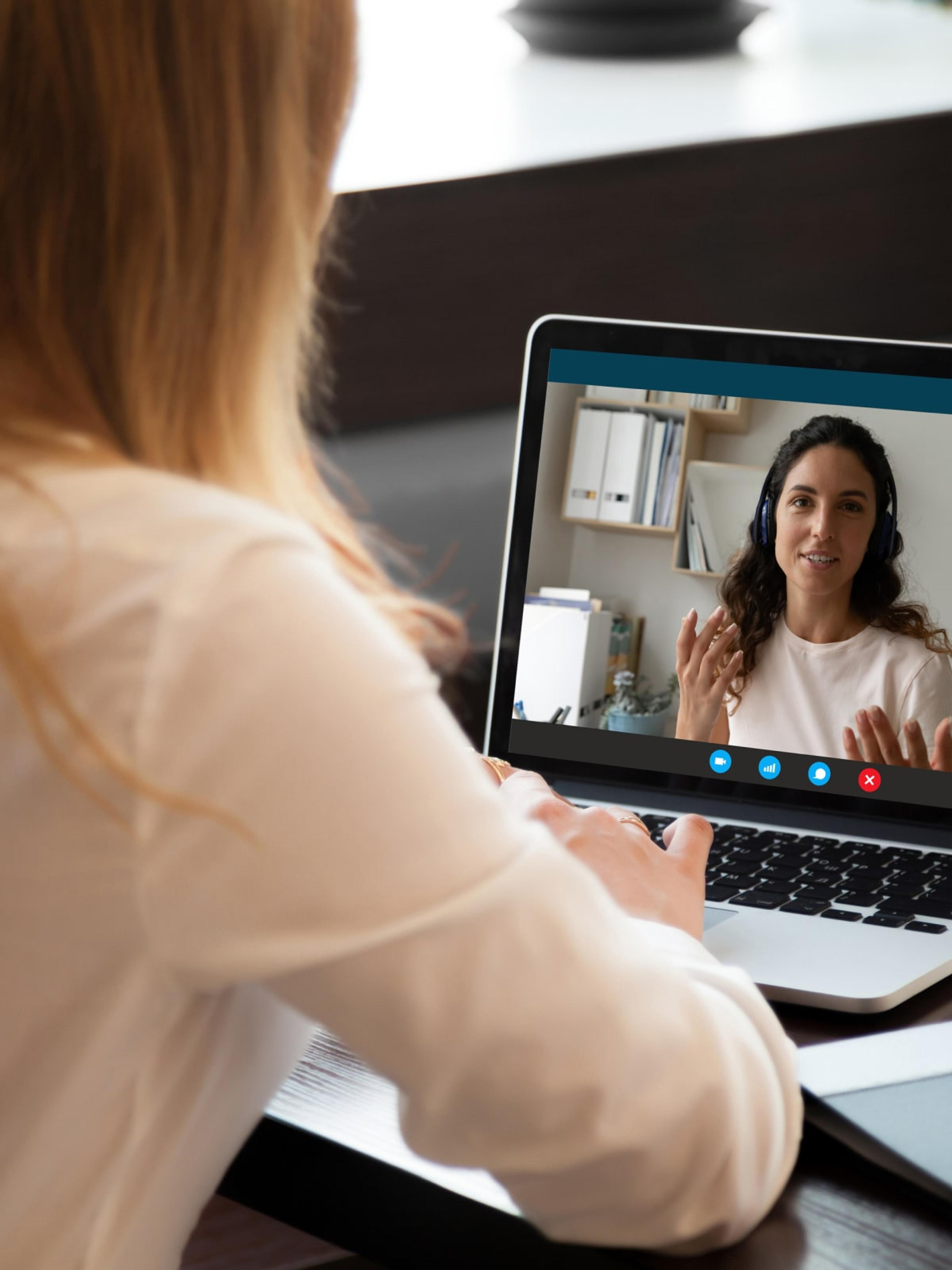 A woman participating in a video call with her coach, who is providing guidance and advice, highlighting the remote coaching support available through Adapt's coach-guided program.