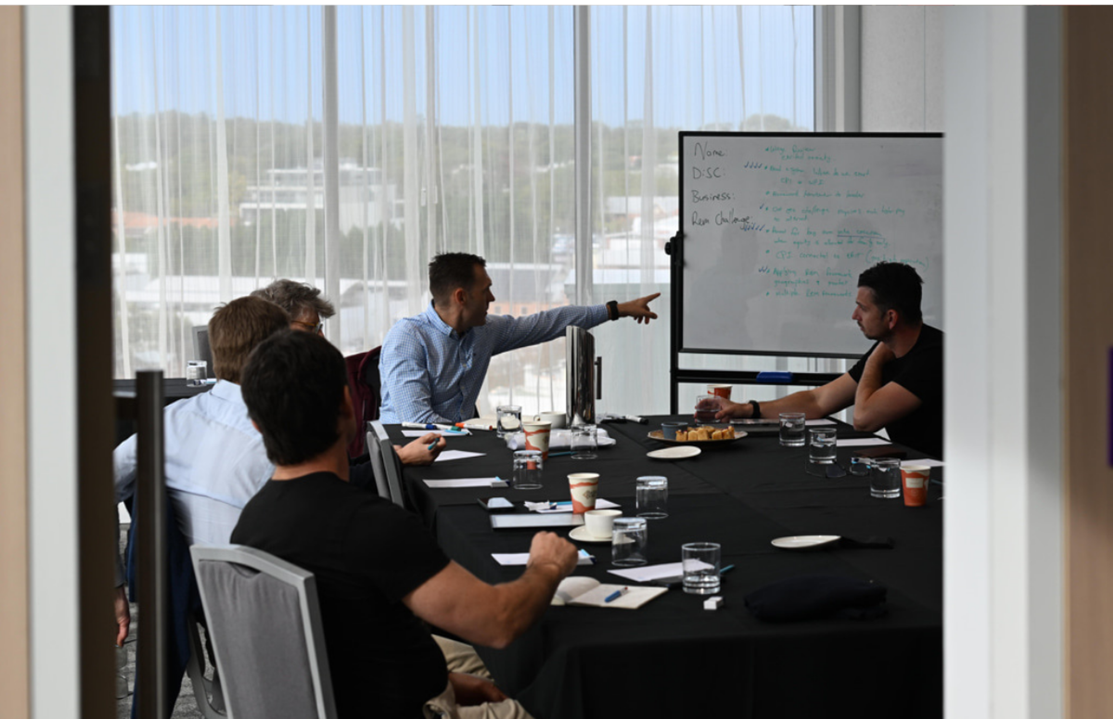 Executive business coach brainstorming strategy with a small team of business leaders