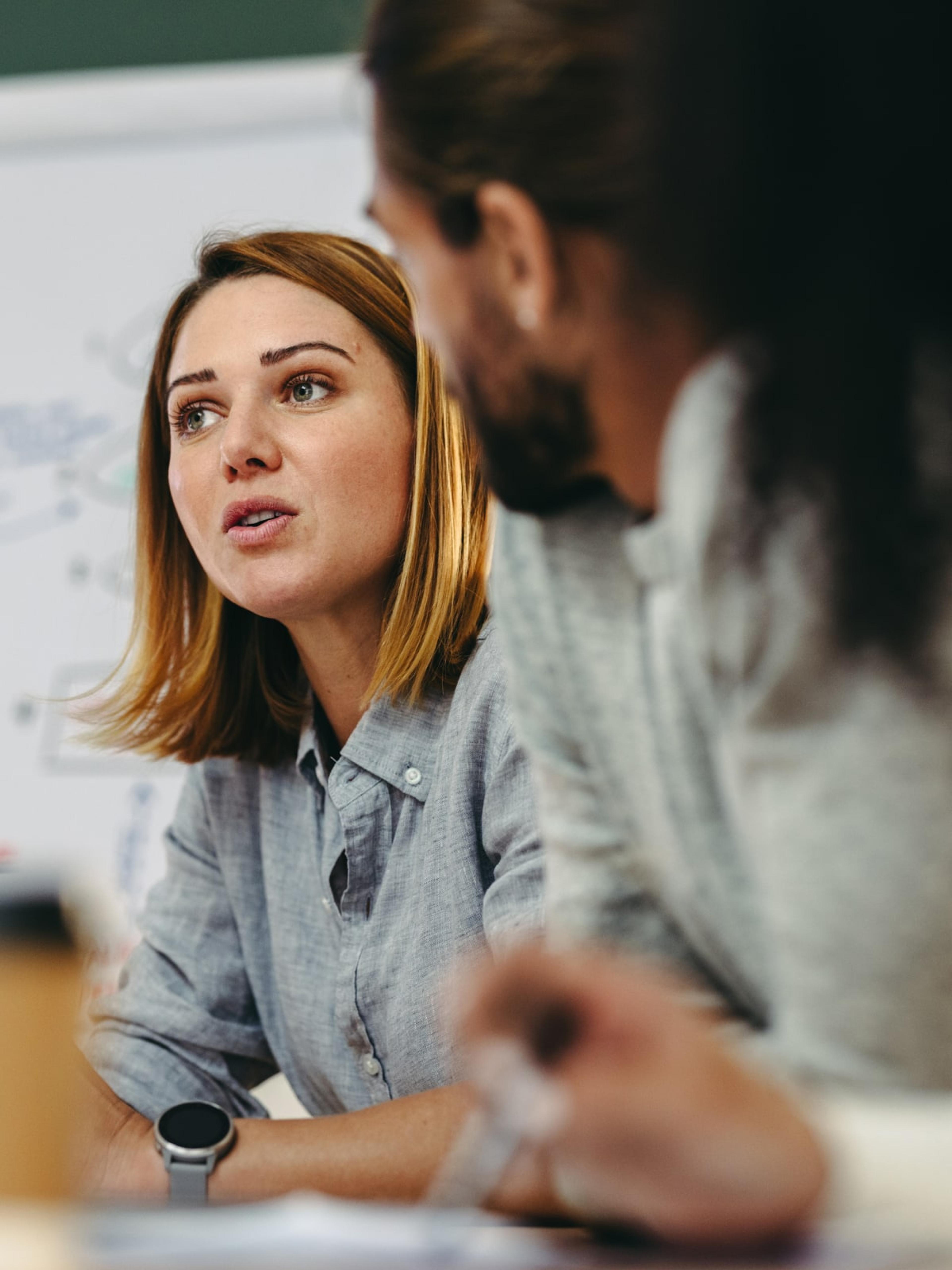 A female business leader engaged in a strategic discussion with a colleague, representing the personalised guidance offered in Adapt's coach-guided program.