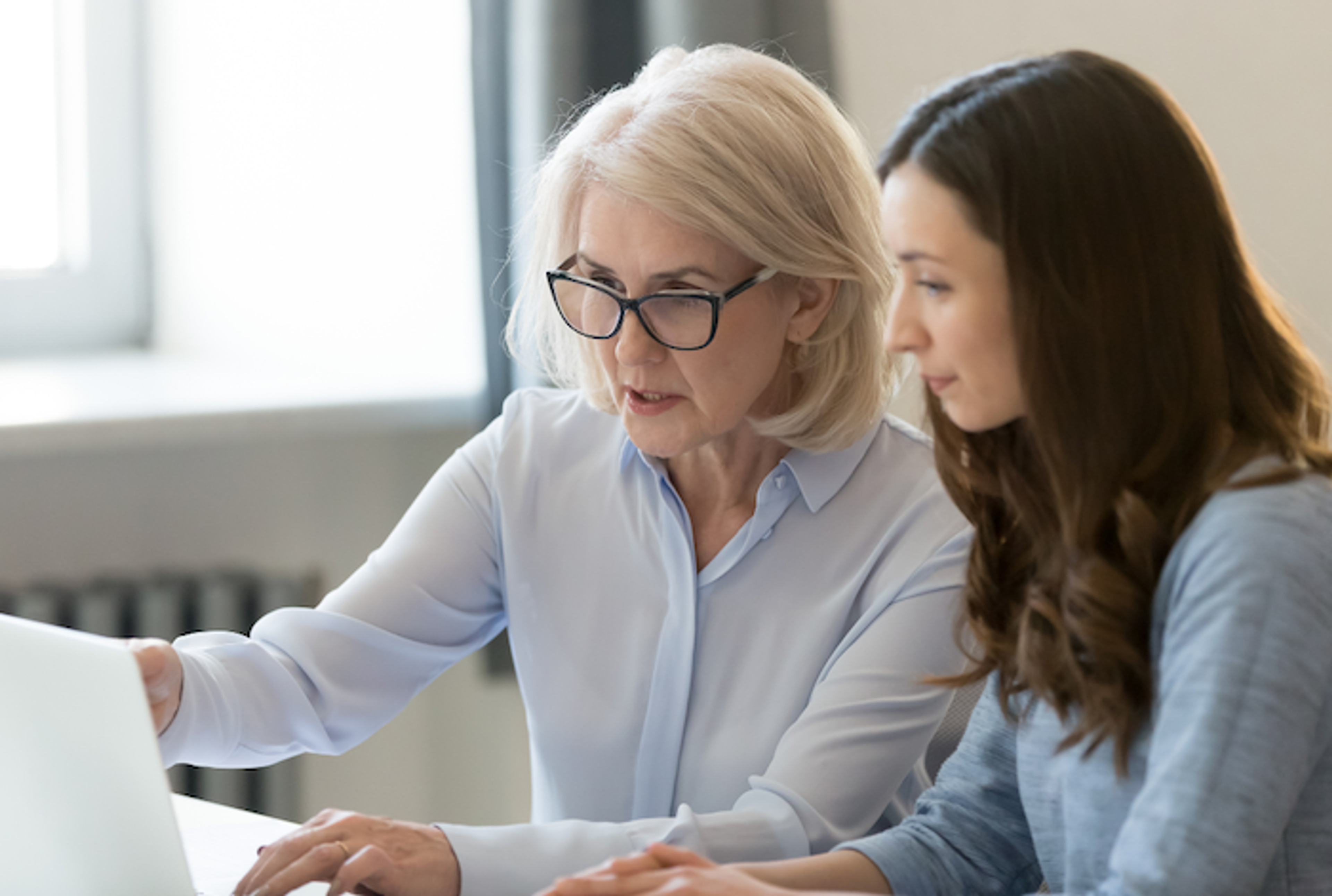Business coach and mentor guiding a professional team through collaborative growth strategies in a modern office setting.