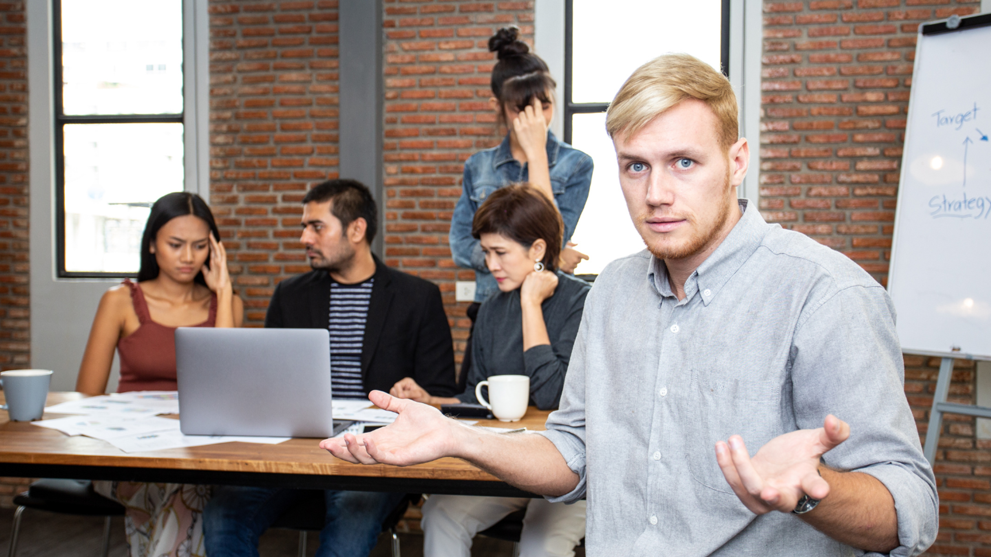 Close-up of a leadership team member presenting a strategy with a whiteboard in the background