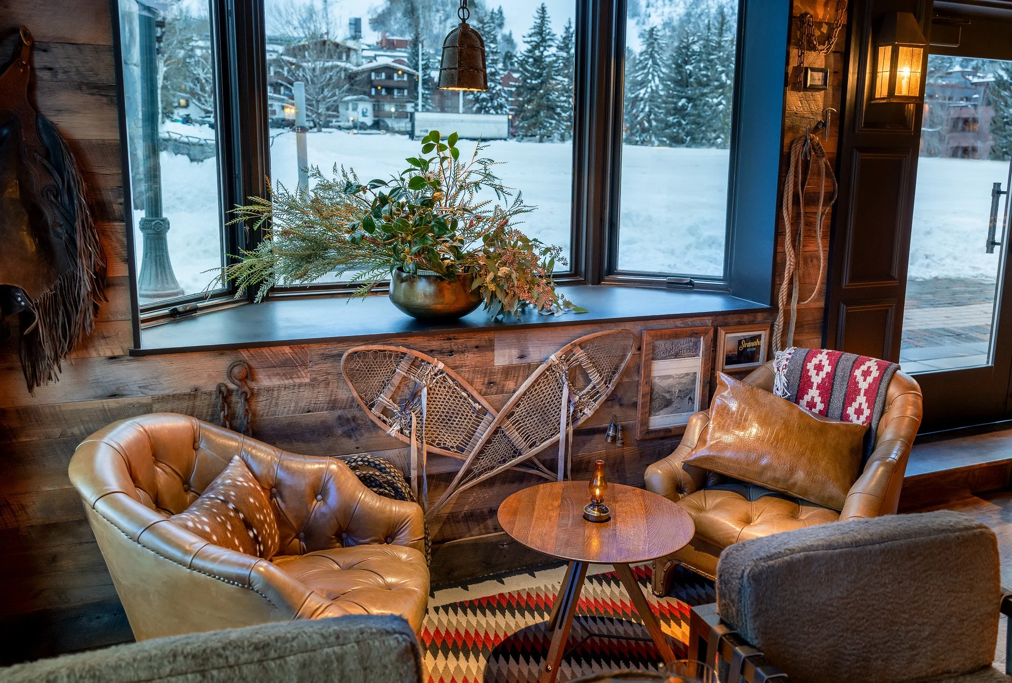 A living room with chairs by a window with snow outside