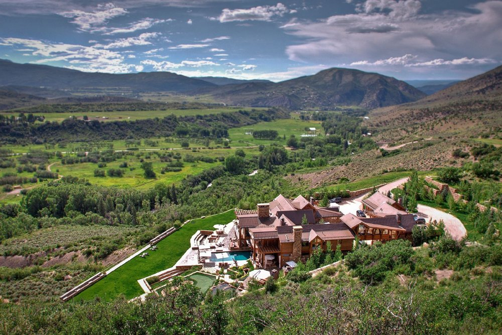 A birds eye view of a house nestled between mountains