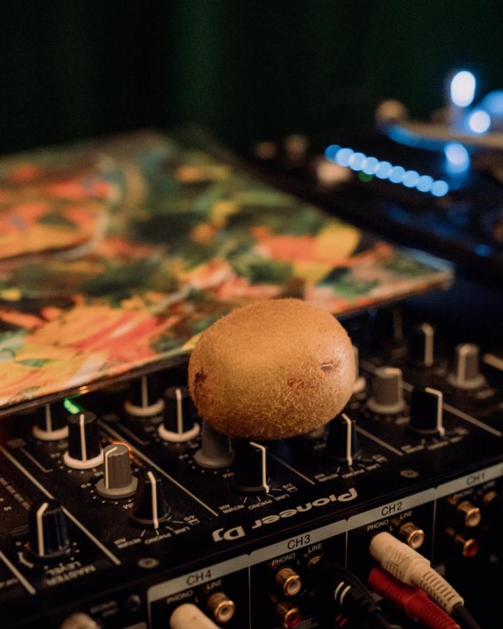 A kiwifruit on a DJ mixer