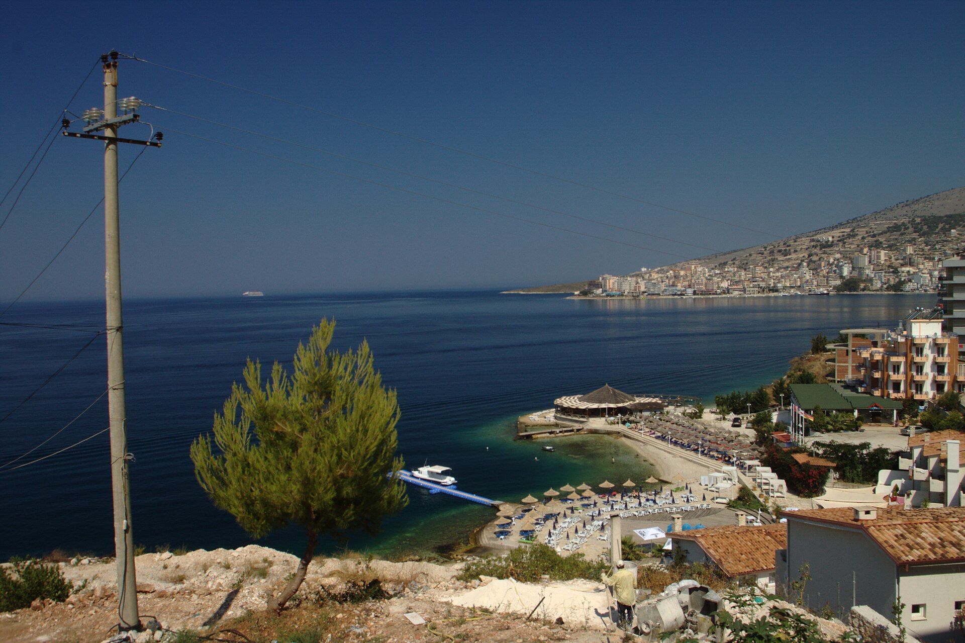 The coast along Rruga Butrinti, looking back towards central Sarandë — Aktron (Wikimedia Commons)