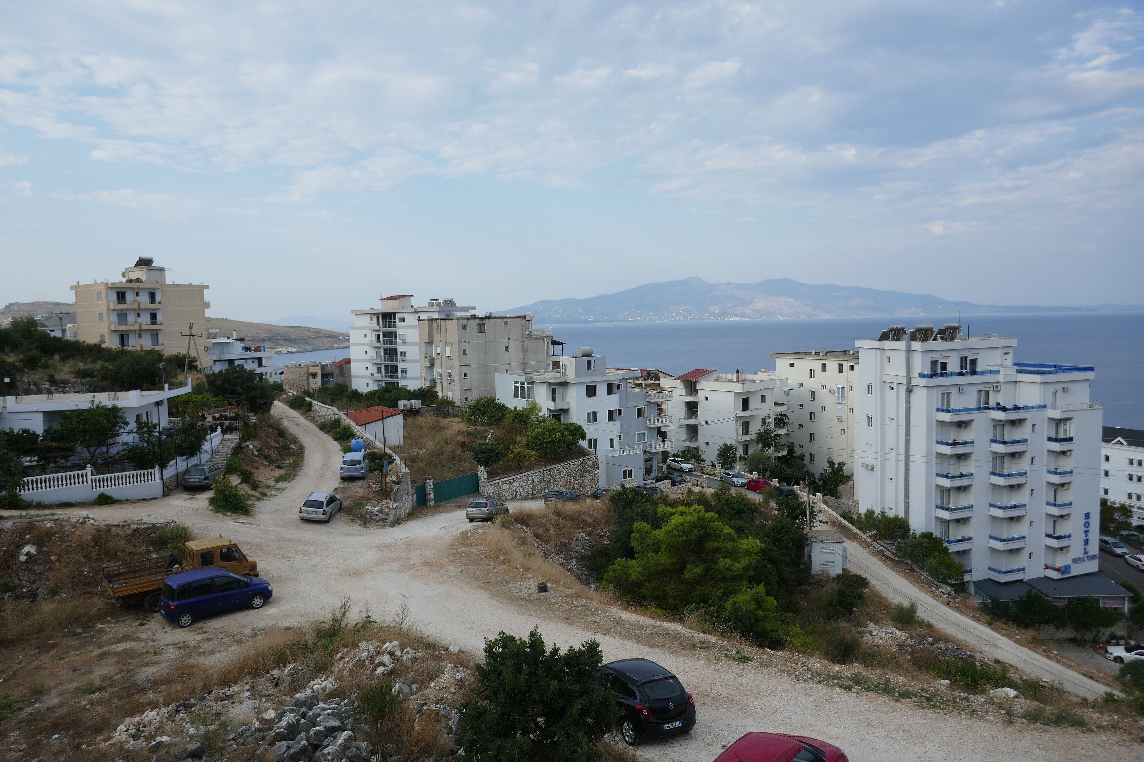 Apartment buildings above the bay at Sarandë, looking towards Corfu — Wilrooij