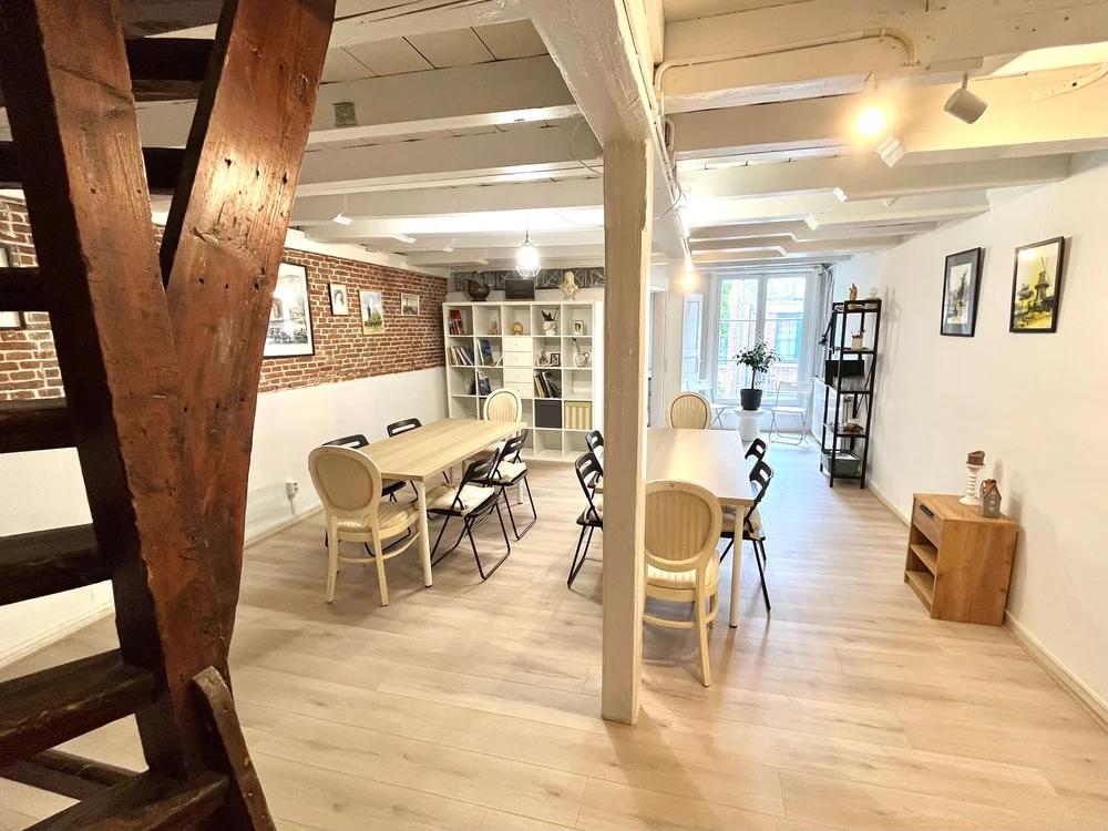 Cozy 39 m² loft space with exposed brick wall, tables, chairs and adjustable lighting for creative meetings or small gatherings