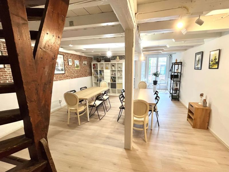Cozy 39 m² loft space with exposed brick wall, tables, chairs and adjustable lighting for creative meetings or small gatherings