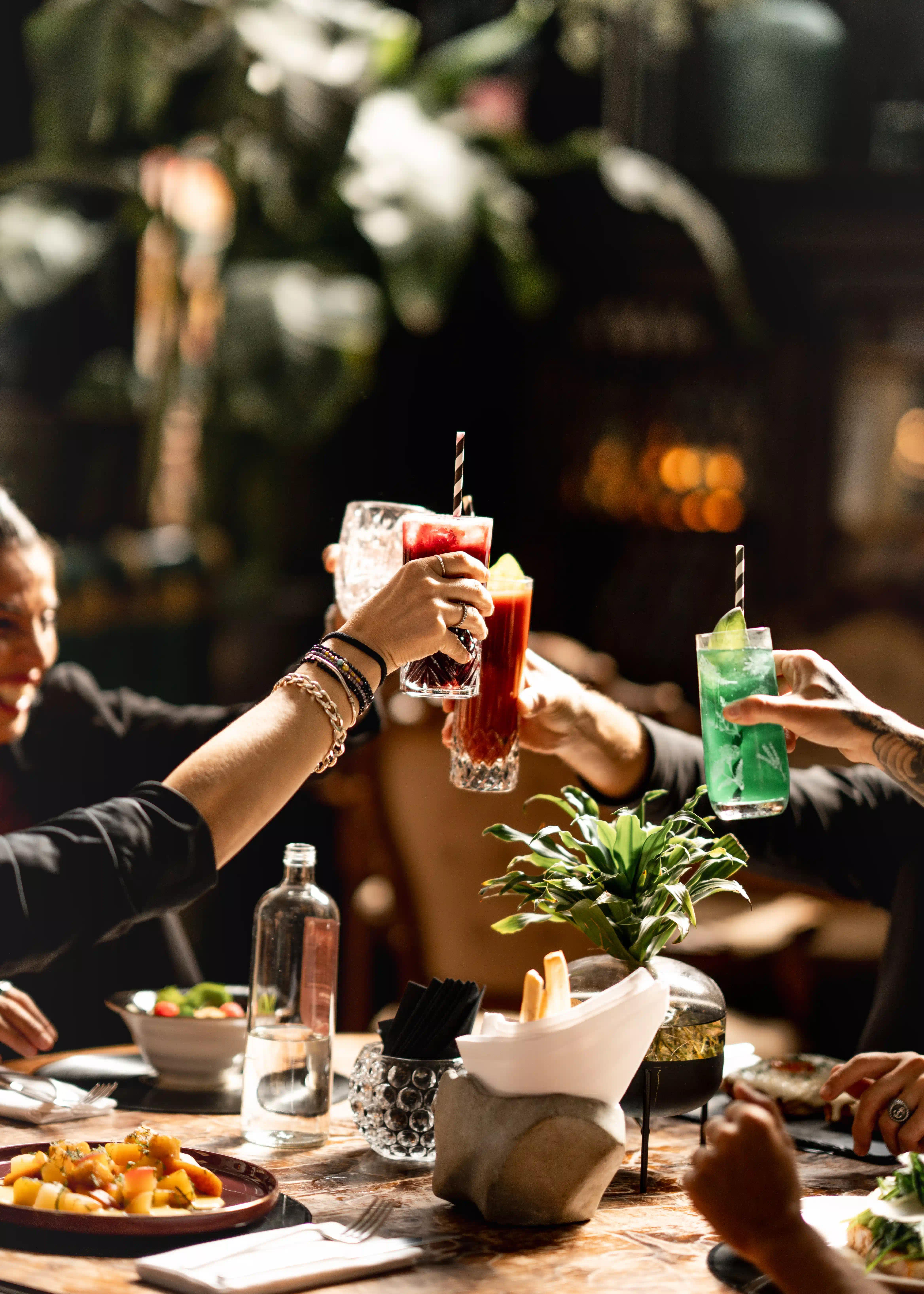 Persone felici che brindano con dei drink colorati al TAD Treviso