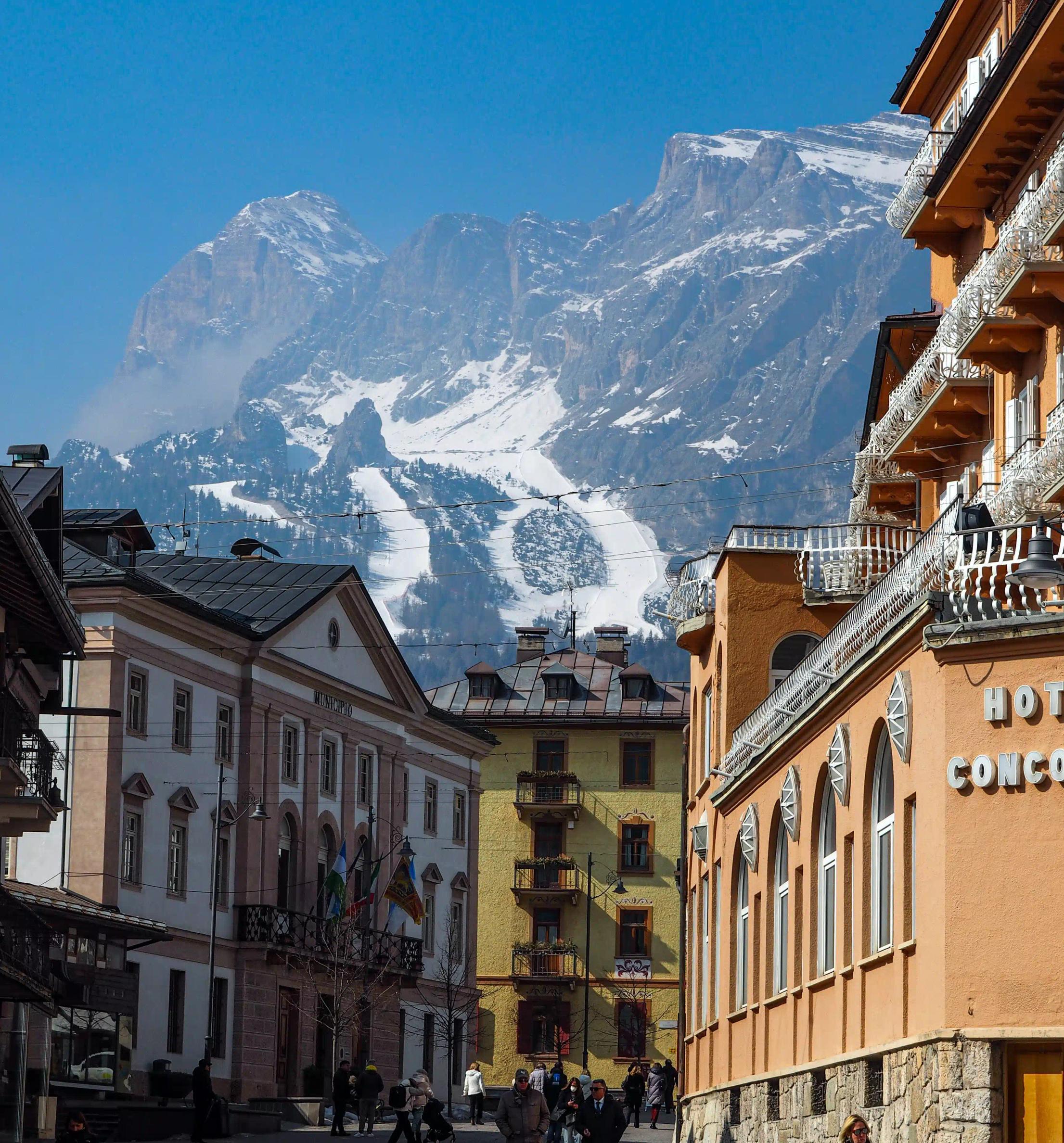 Via principale di Cortina con le montagne innevate sullo sfondo in lontananza
