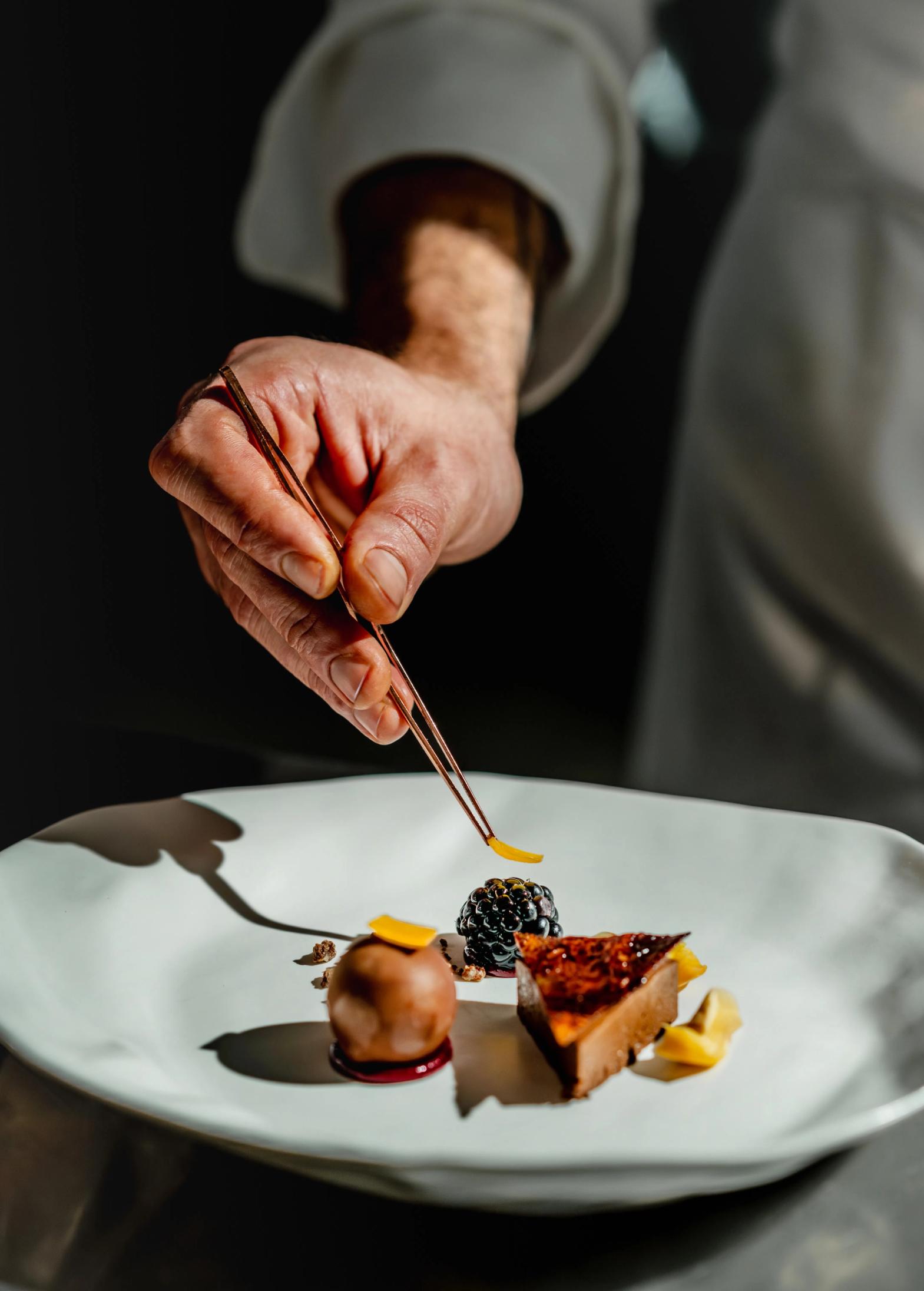 Lo Chef Simone Selva che termina la preparazione di una portata