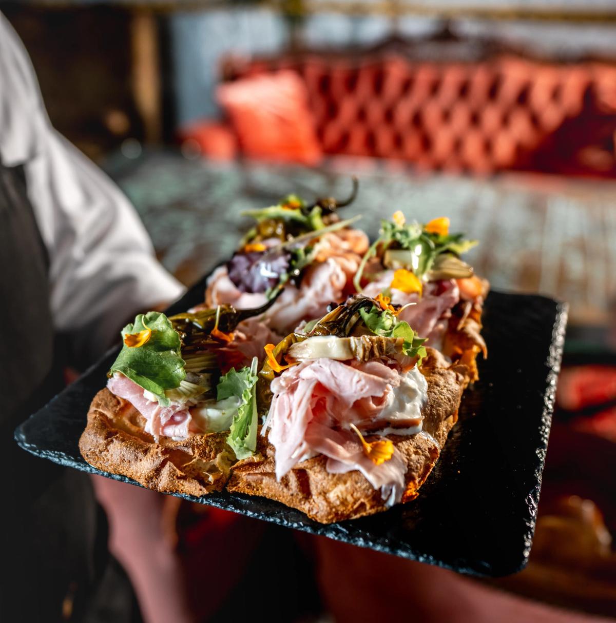 Piatto in ardesia con sopra una focaccia gourmet