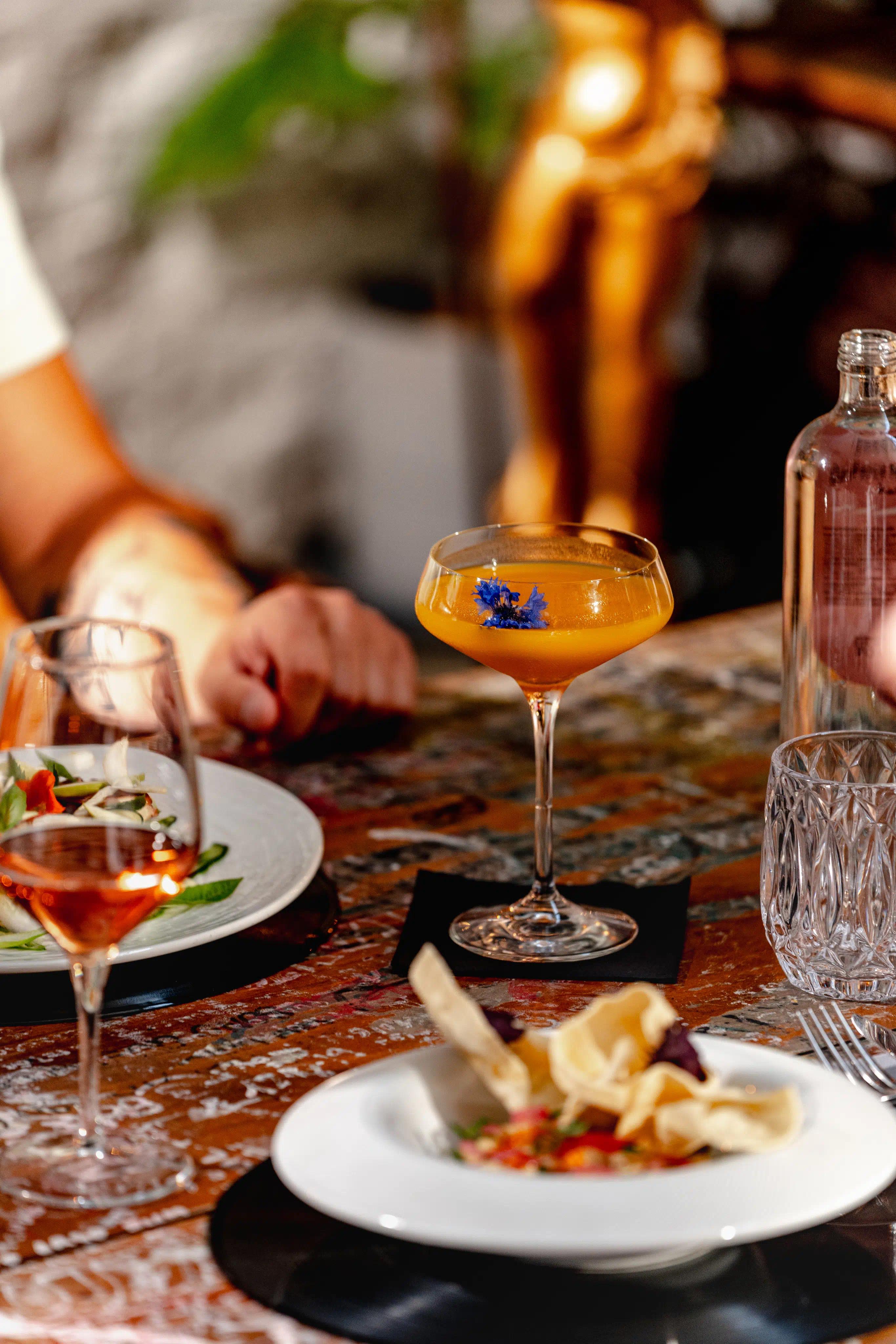 Drink arancione con al suo interno un fiore blu