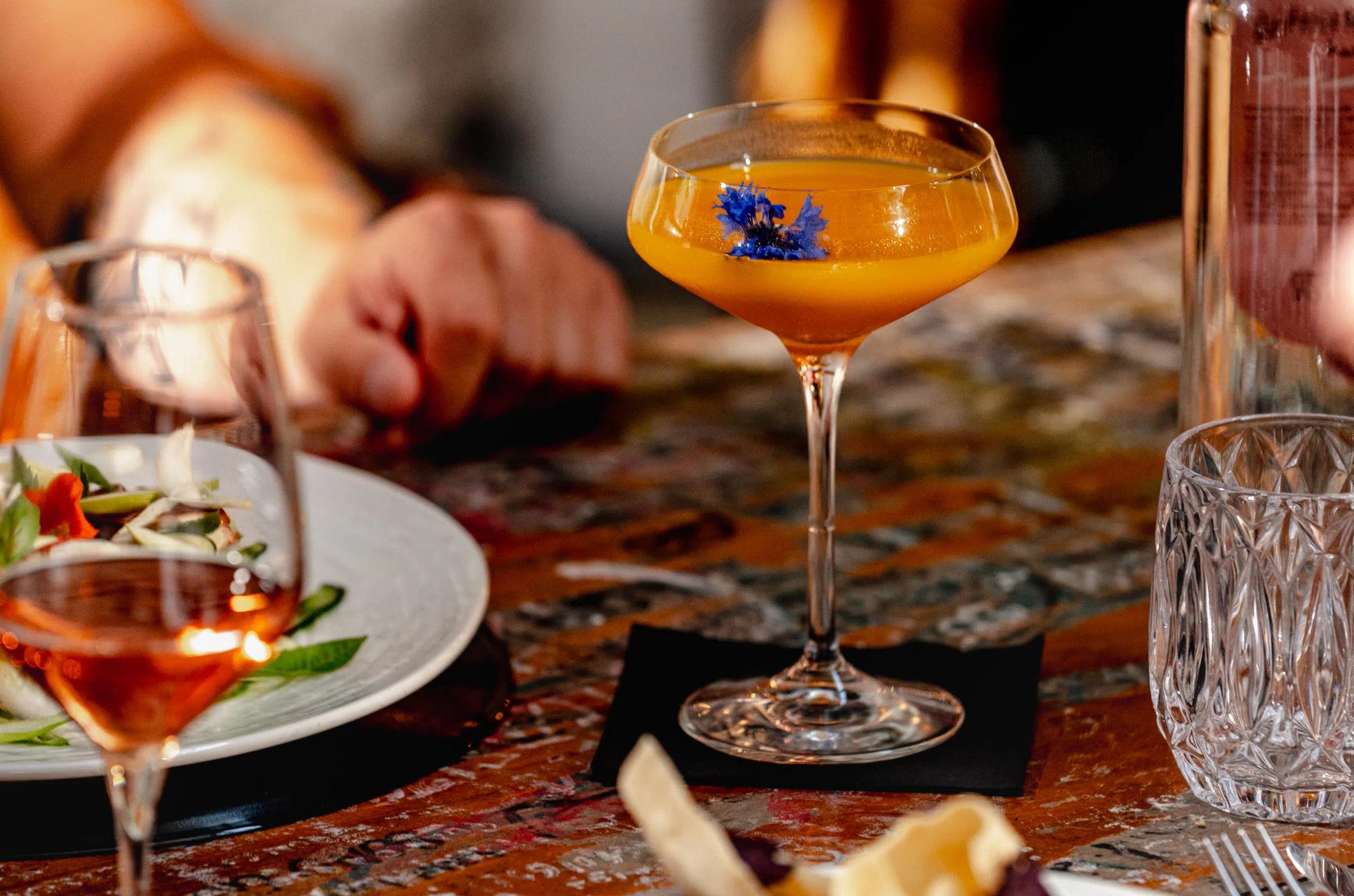 Drink arancione con al suo interno un fiore blu