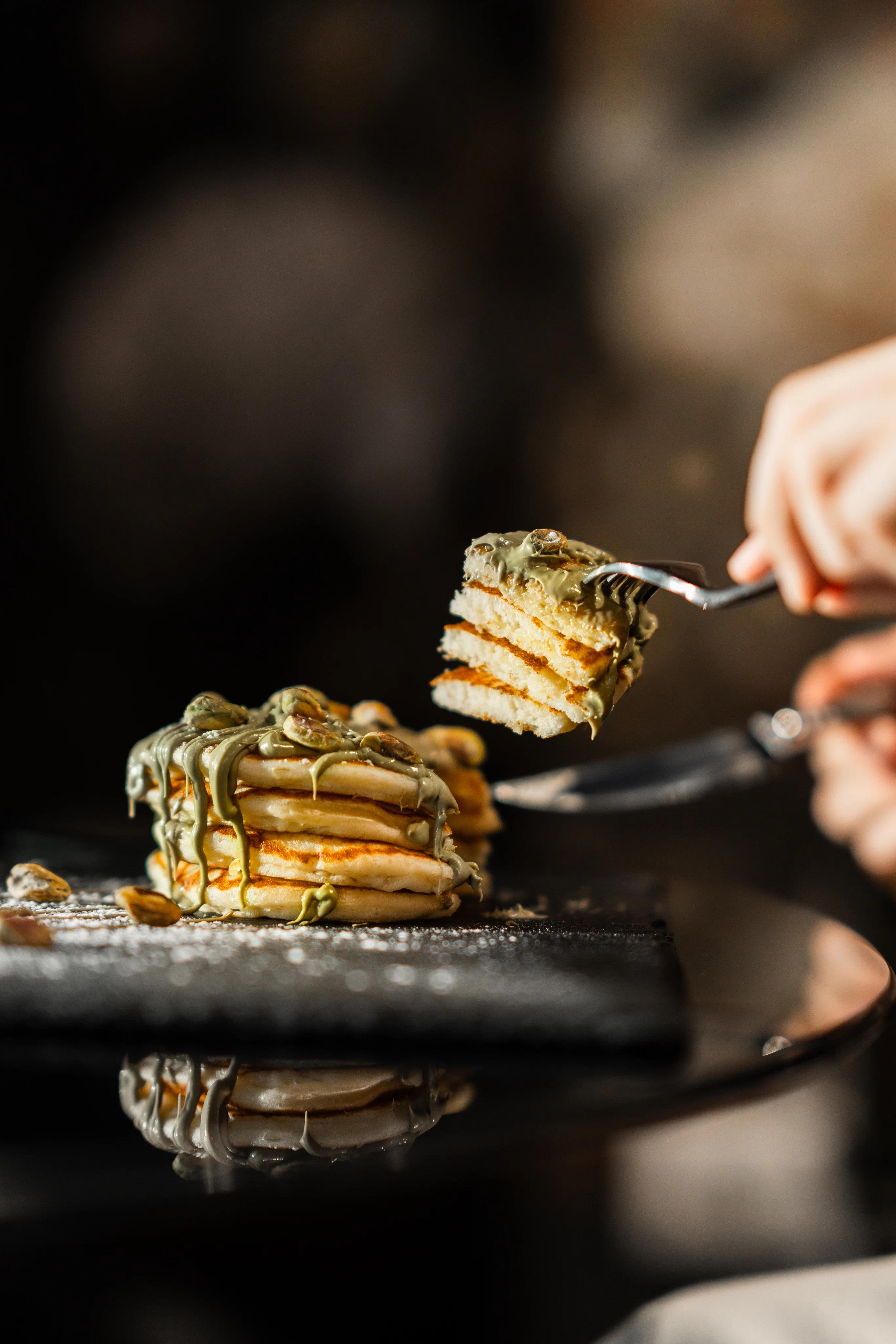 Taglio di una pila di pancake con crema al pistacchio
