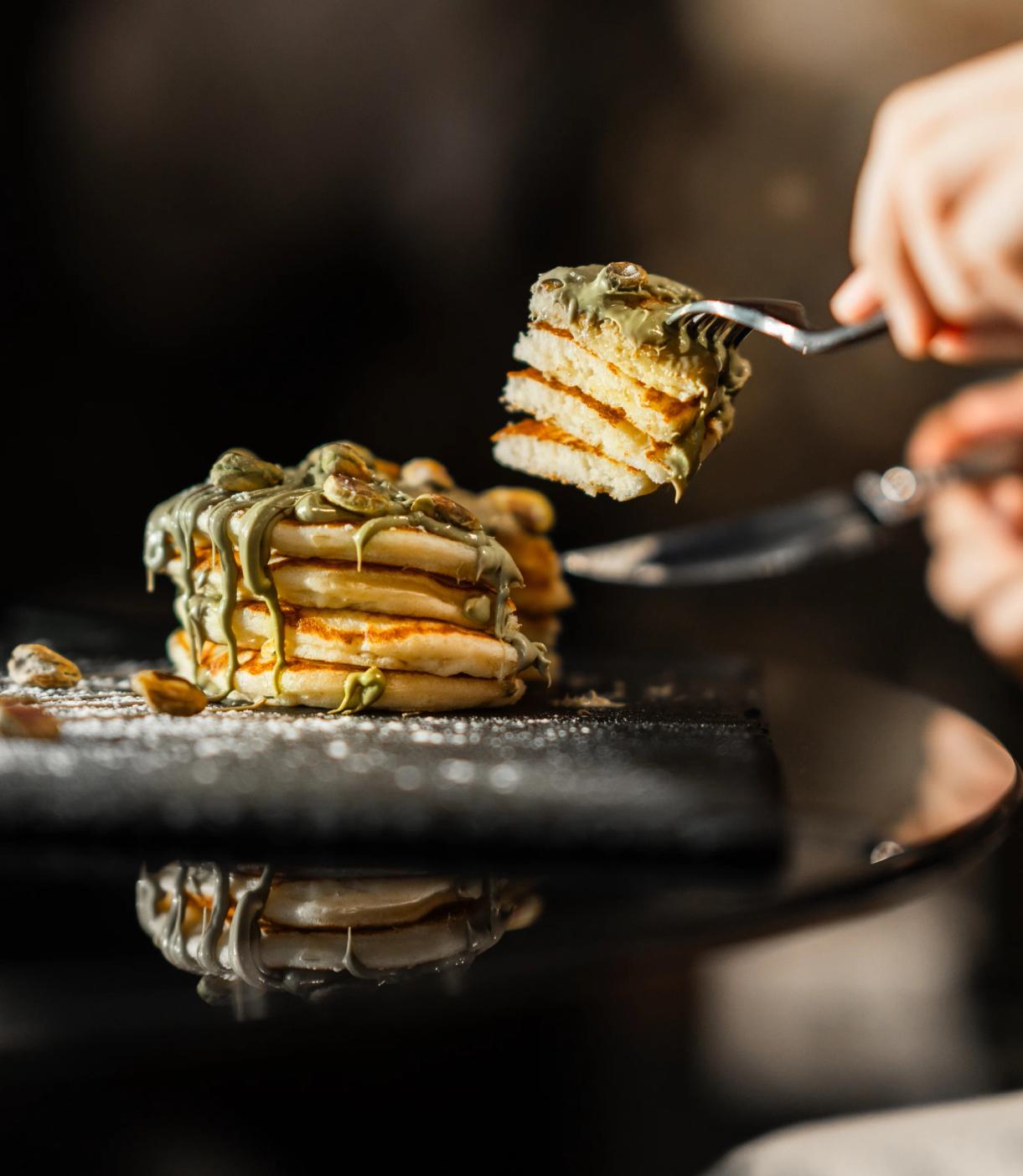 Taglio di una pila di pancake con crema al pistacchio