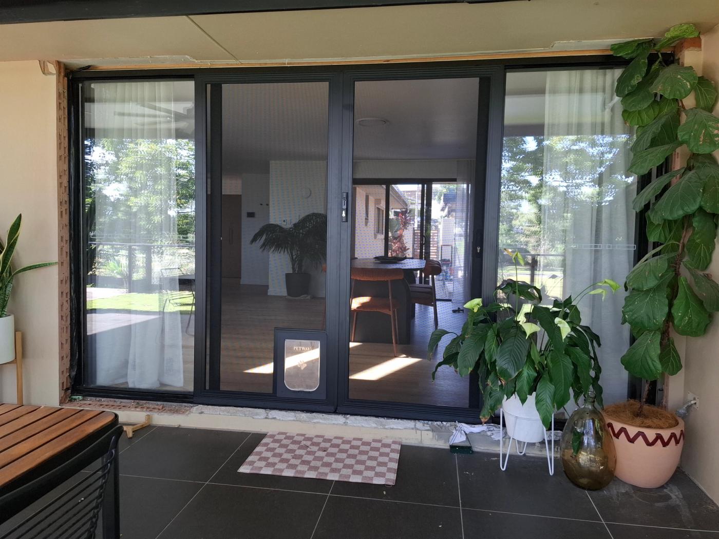 Sliding screen door fitted with a dog door 