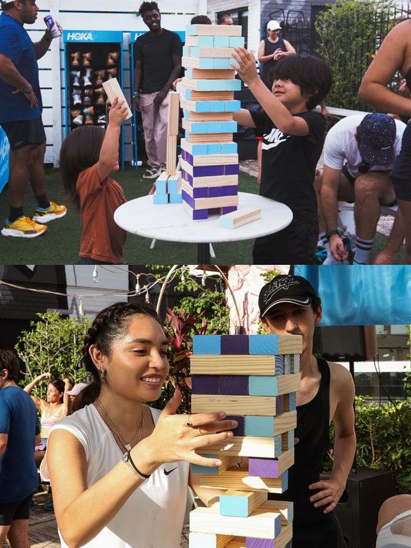 Children and adults play a large wooden block-stacking game at the Roots Fly High gathering.