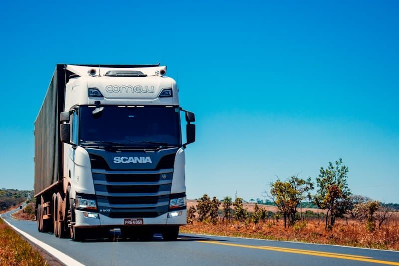 White freight truck on open road — the logistics operations AI calling for freight brokers supports