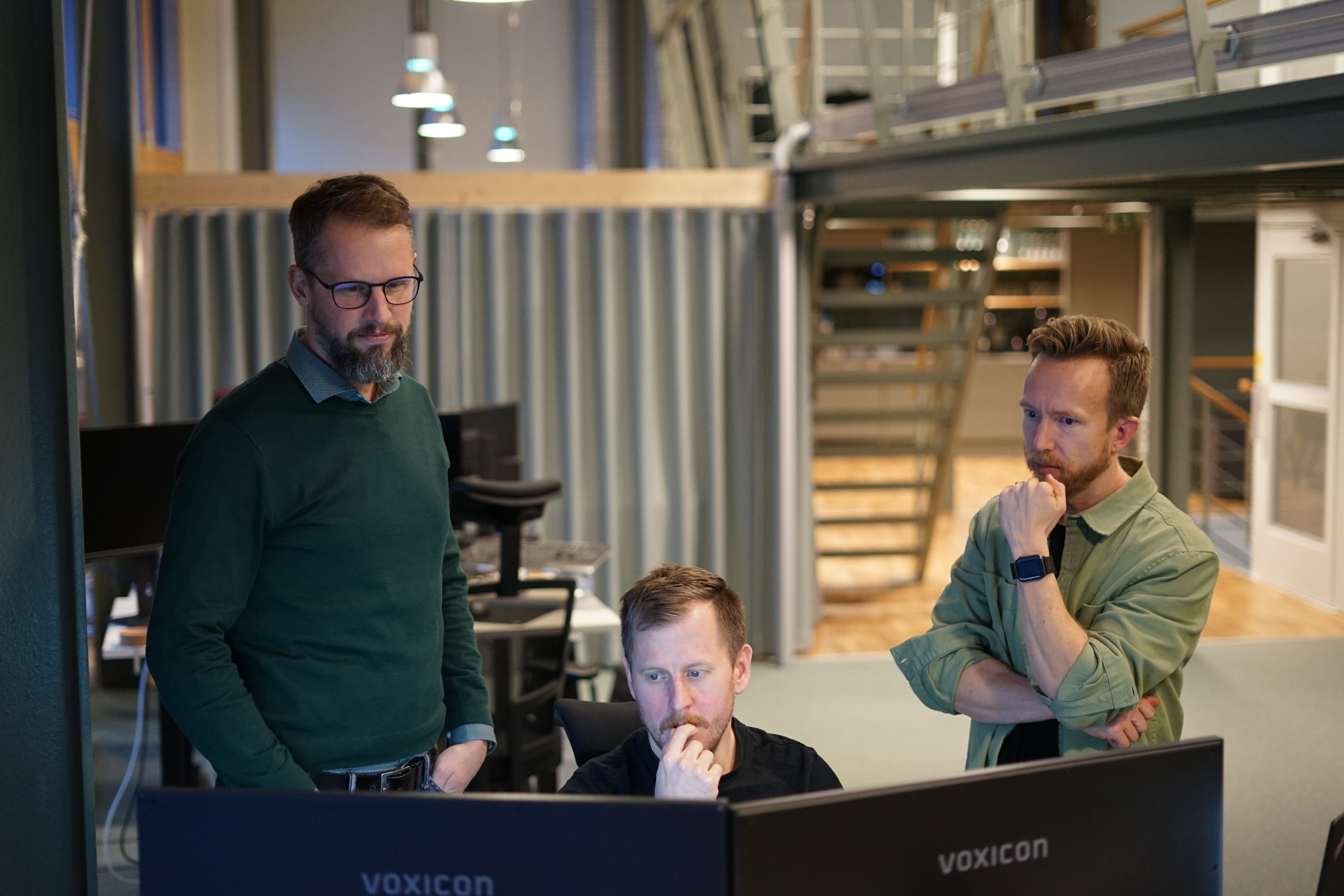 Två män samtalar framfor datorn