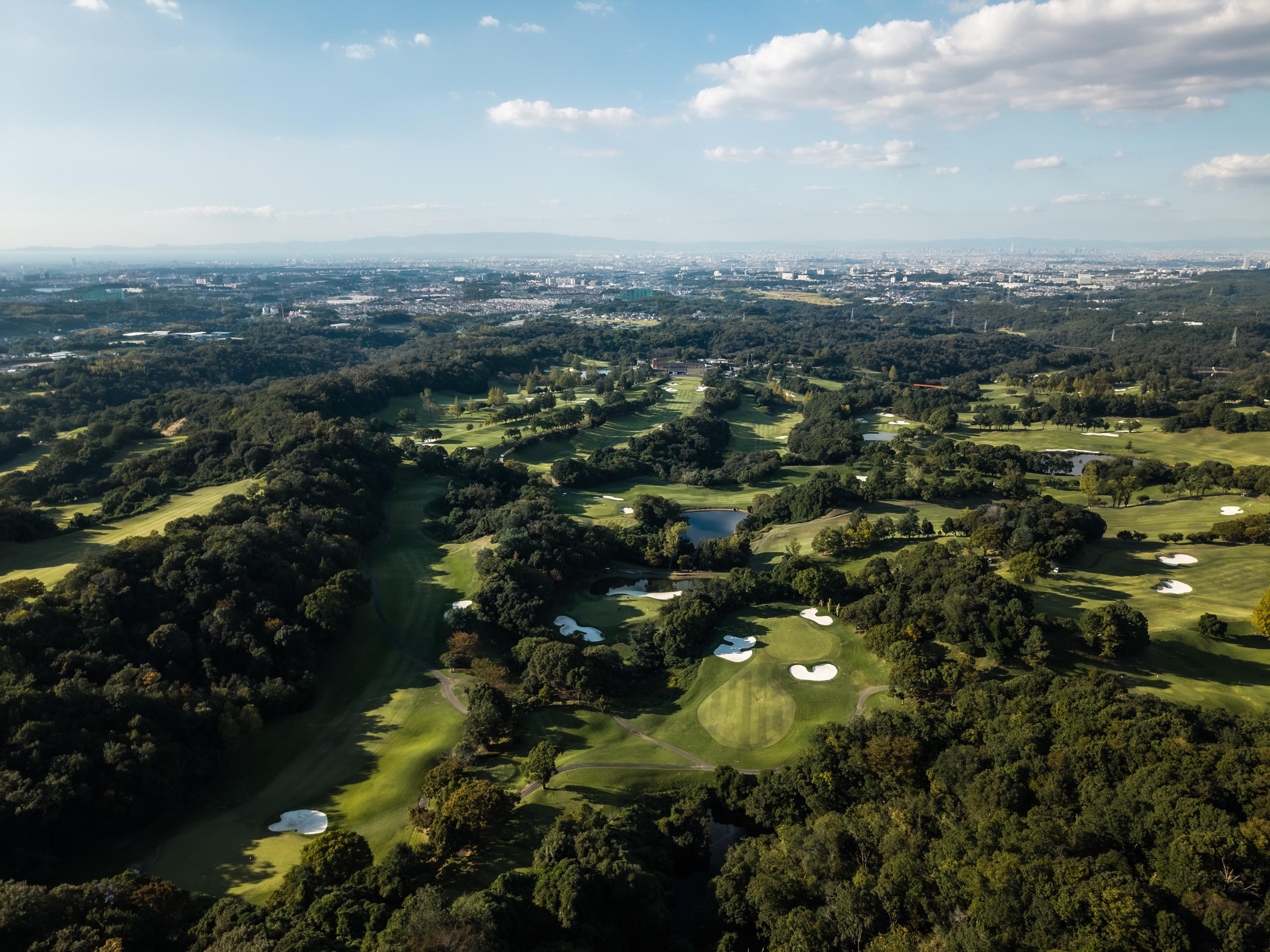 Izumigaoka Country Club from the air, with the Osaka skyline beyond