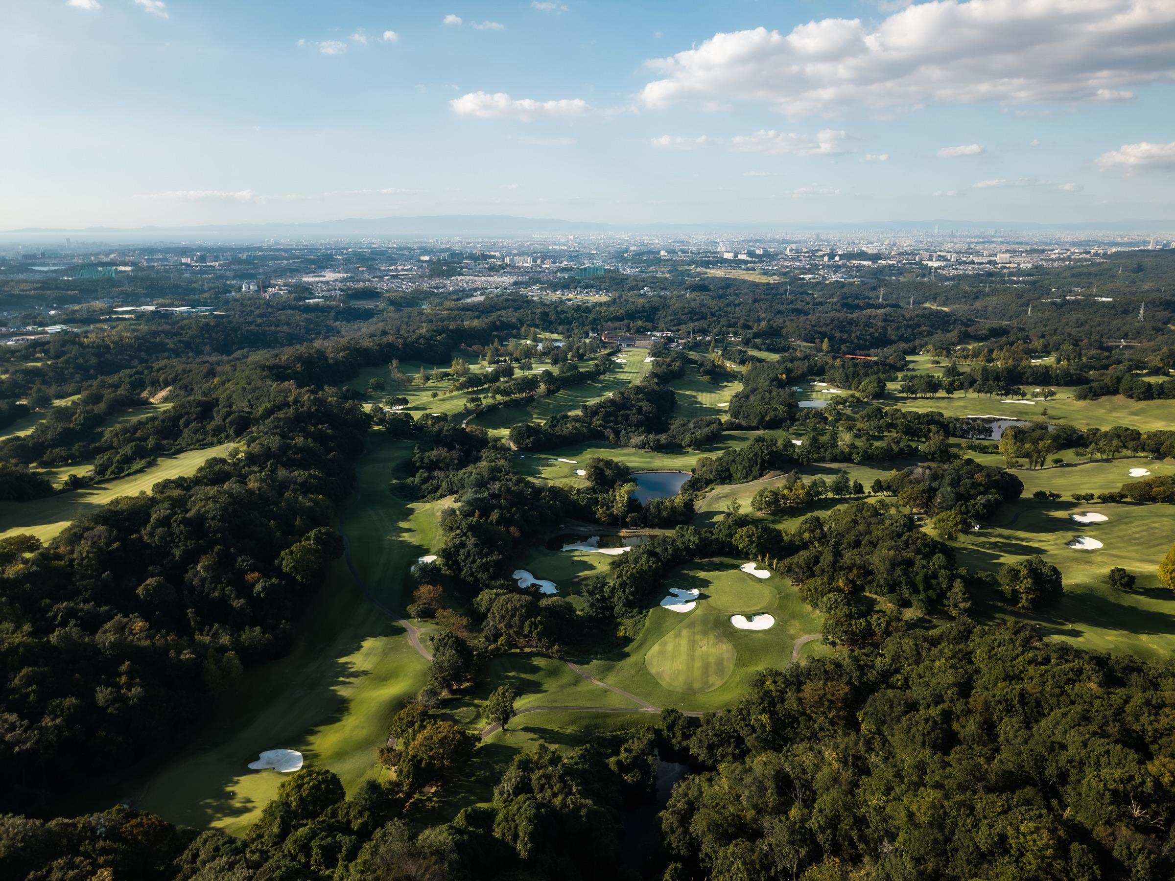 Izumigaoka Country Club from the air, with the Osaka skyline beyond