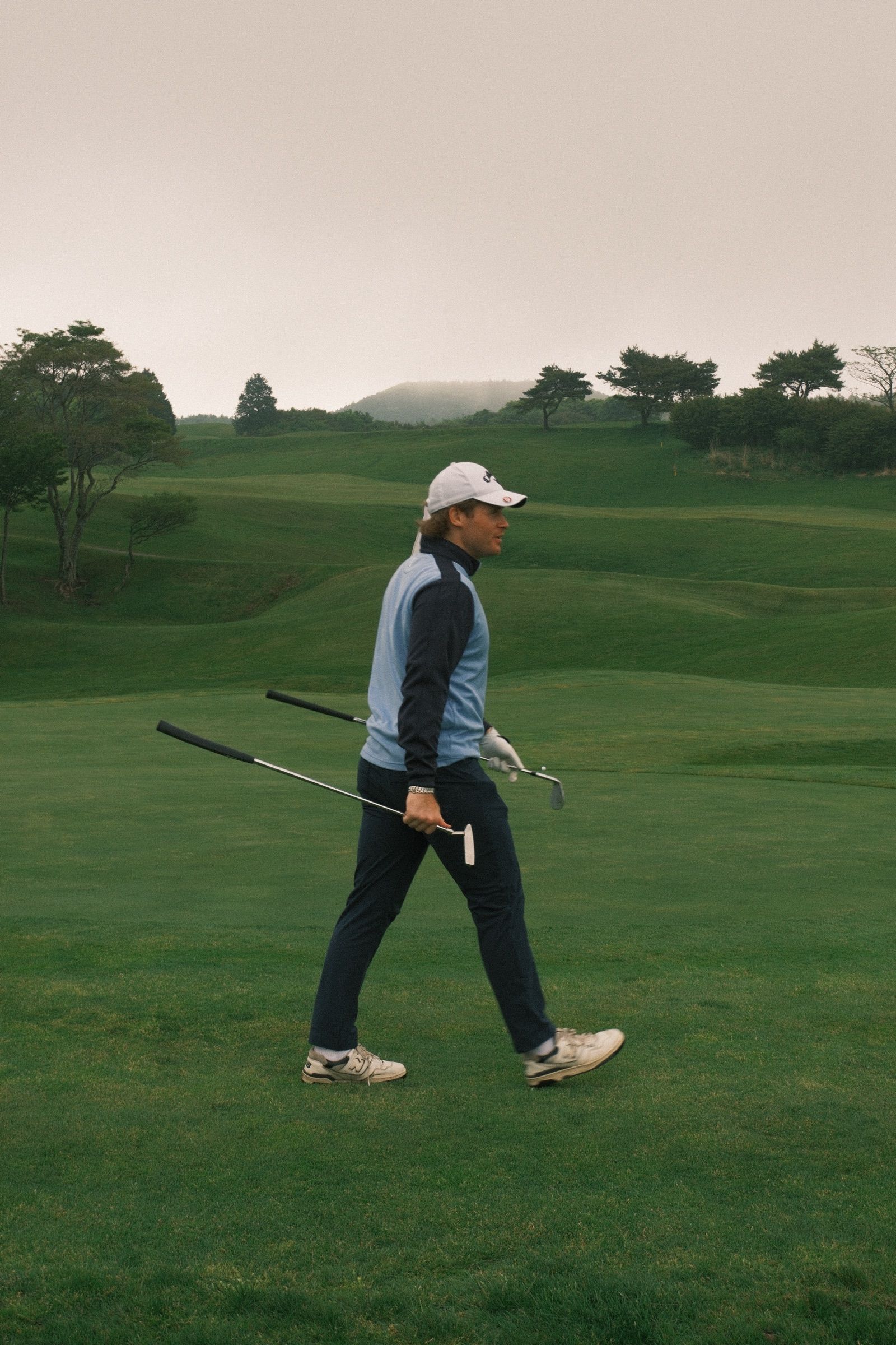 Walking off the green, putter and wedge in hand