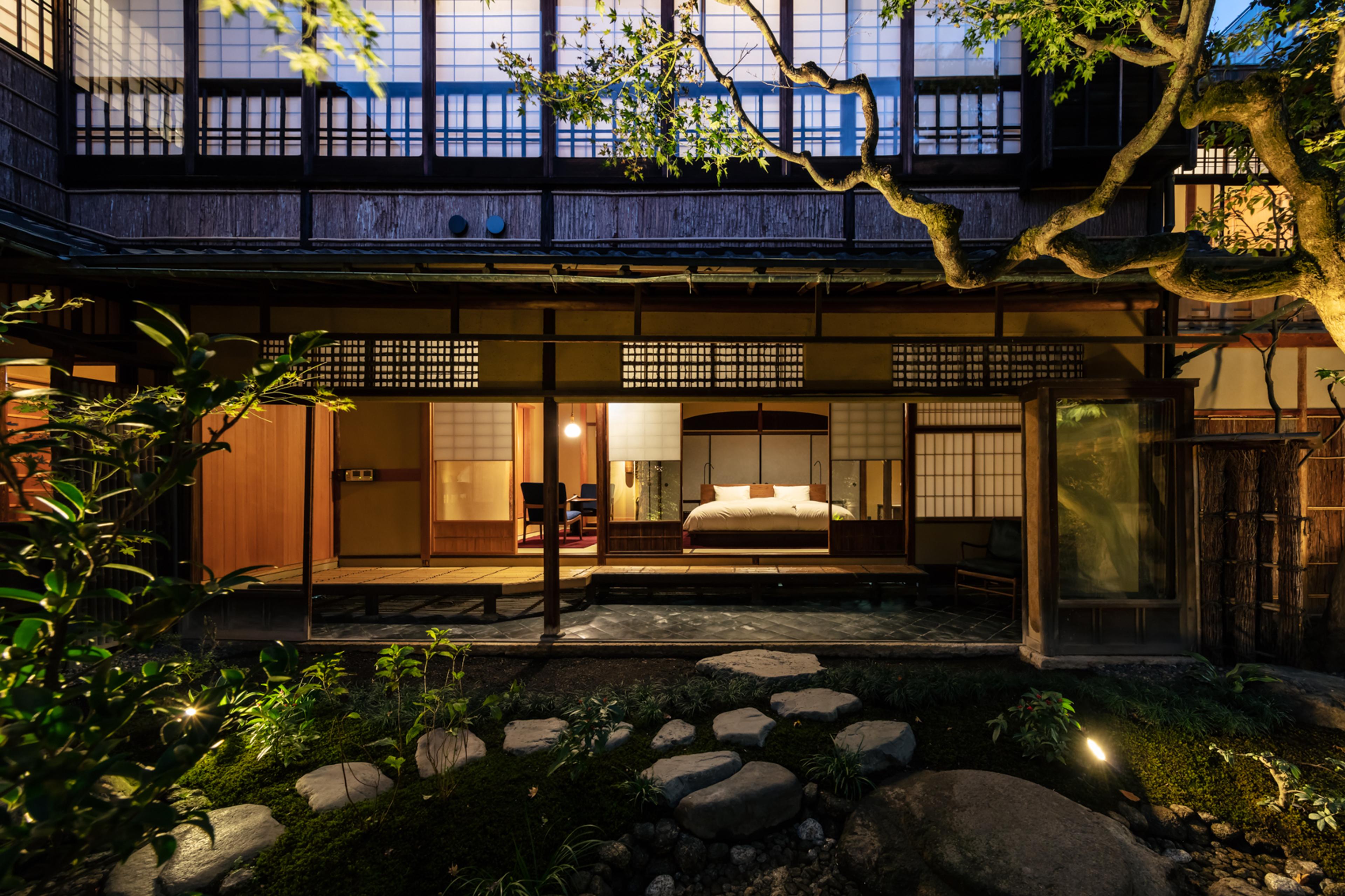 The restored SOWAKA machiya facade in Gion, Kyoto, lit at dusk