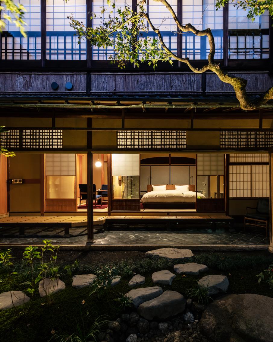 The restored SOWAKA machiya facade in Gion, Kyoto, lit at dusk
