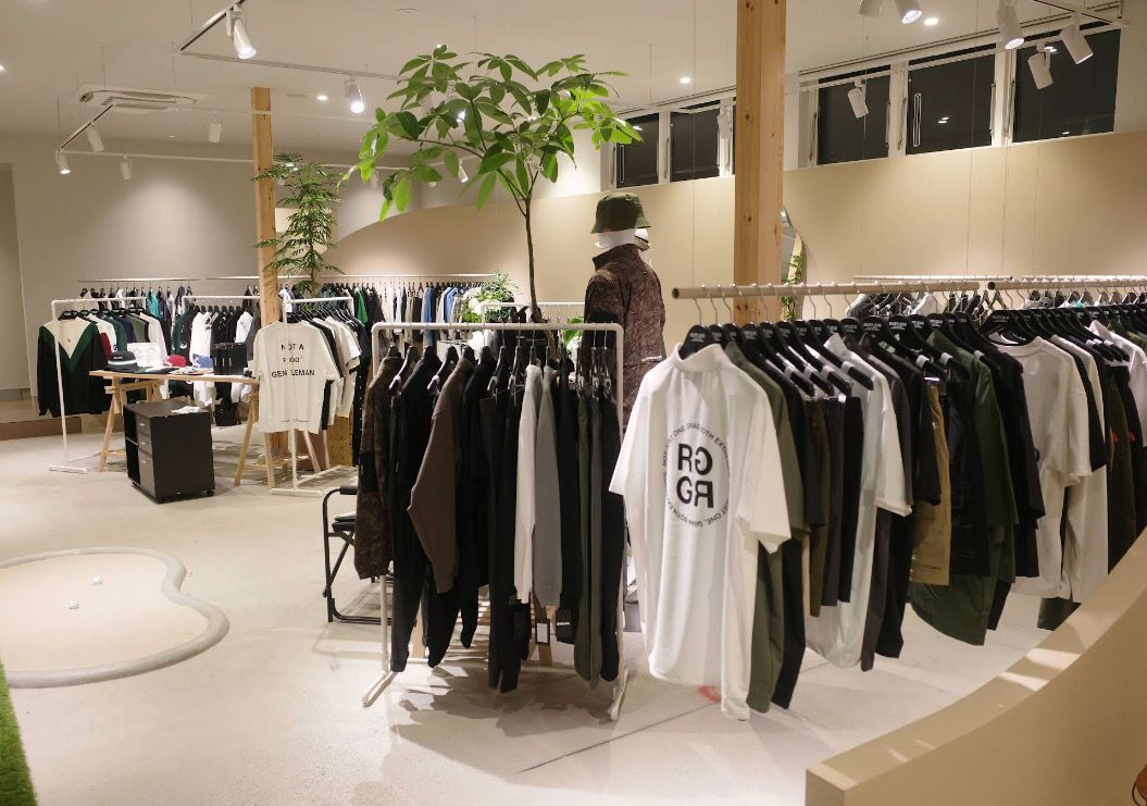 Inside RUFFLOG Kanazawa — golf apparel on racks with an indoor putting mat