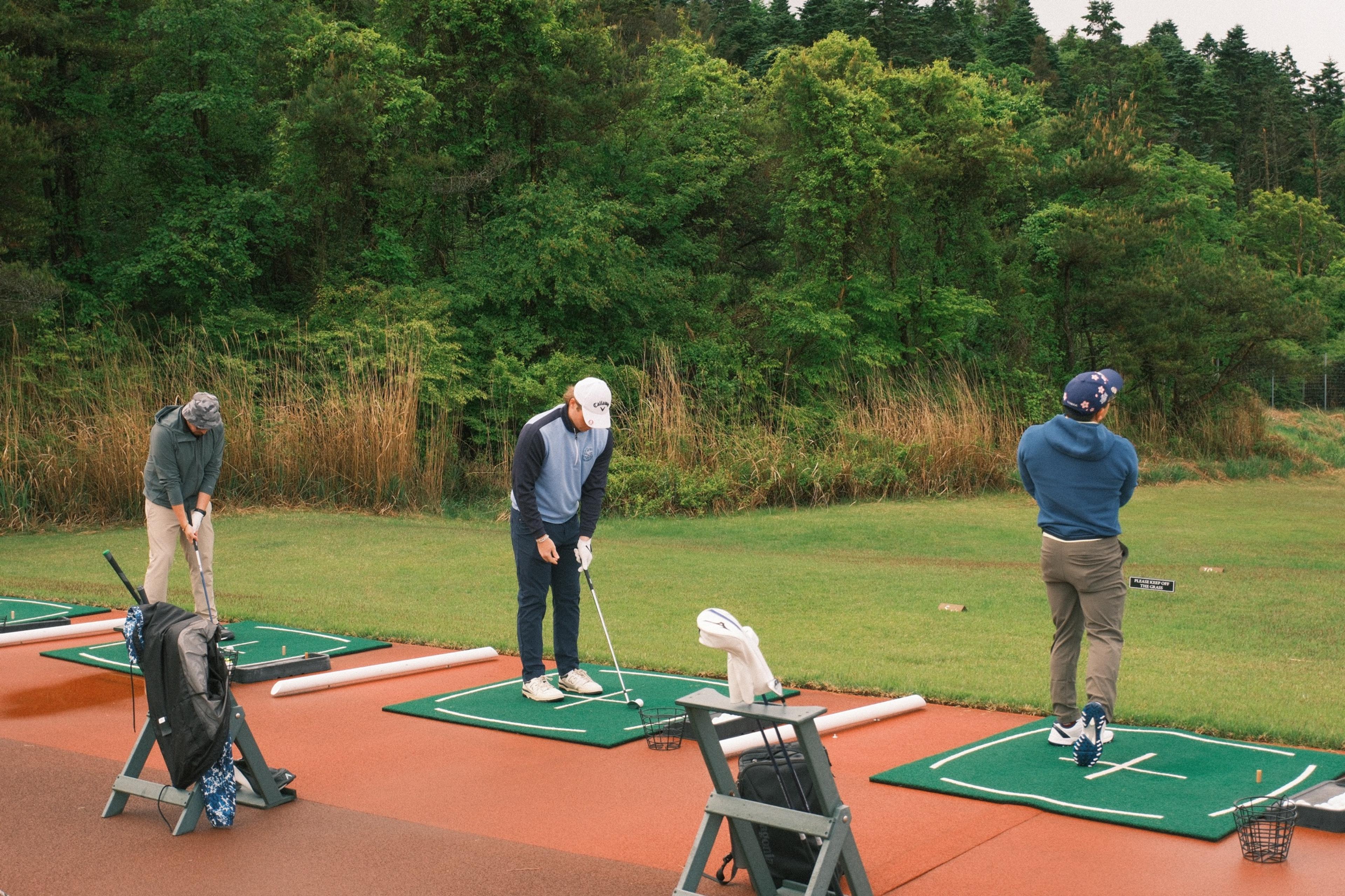 Guests warming up on the driving range at Fuji Classic under a grey May sky