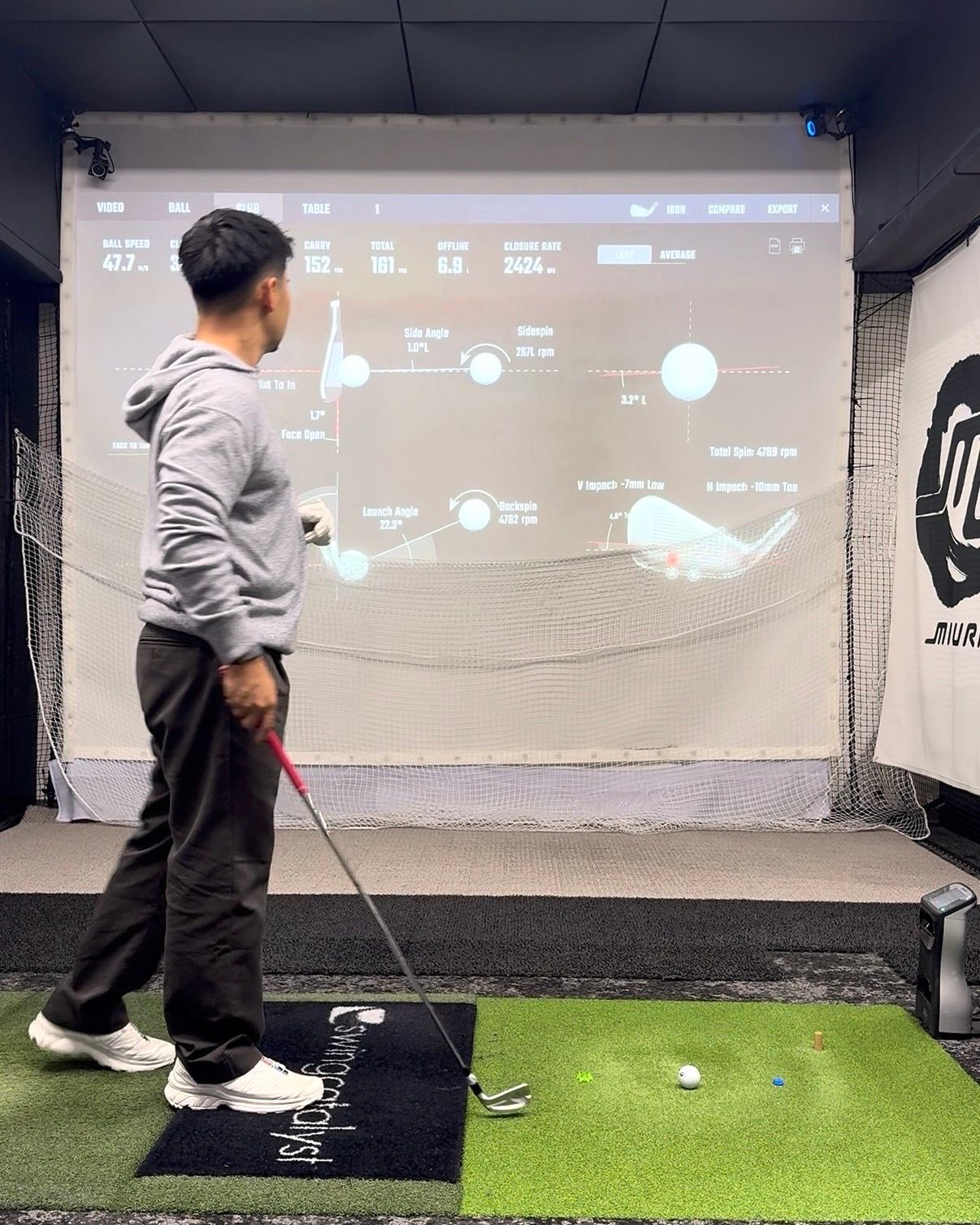 A golfer reviewing launch data in the fitting bay