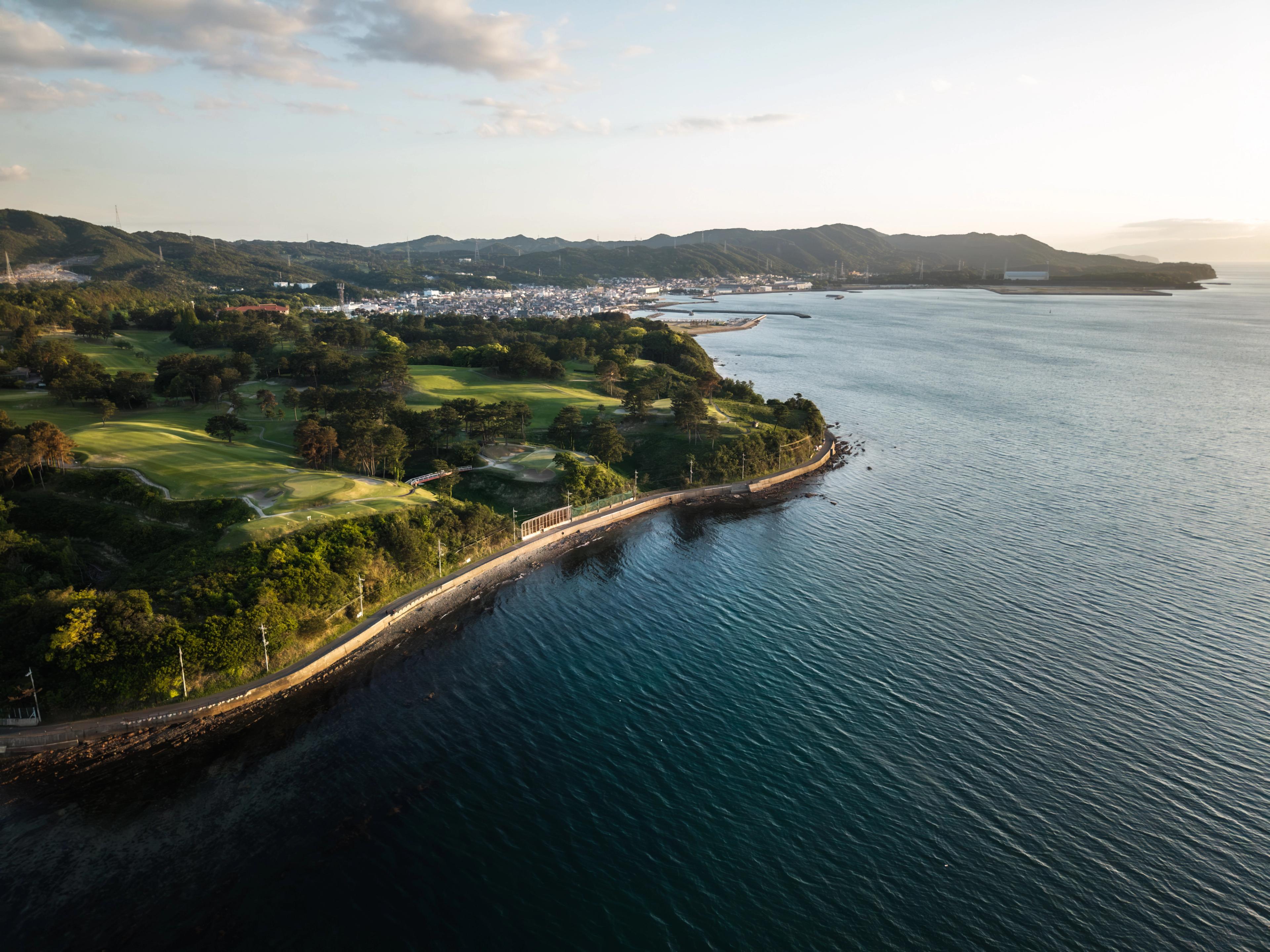 photo of osaka golf club during sunset by ocean