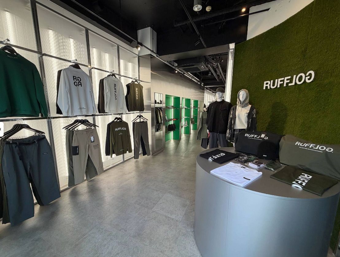 Inside RUFFLOG Osaka — apparel racks and the moss-green logo wall