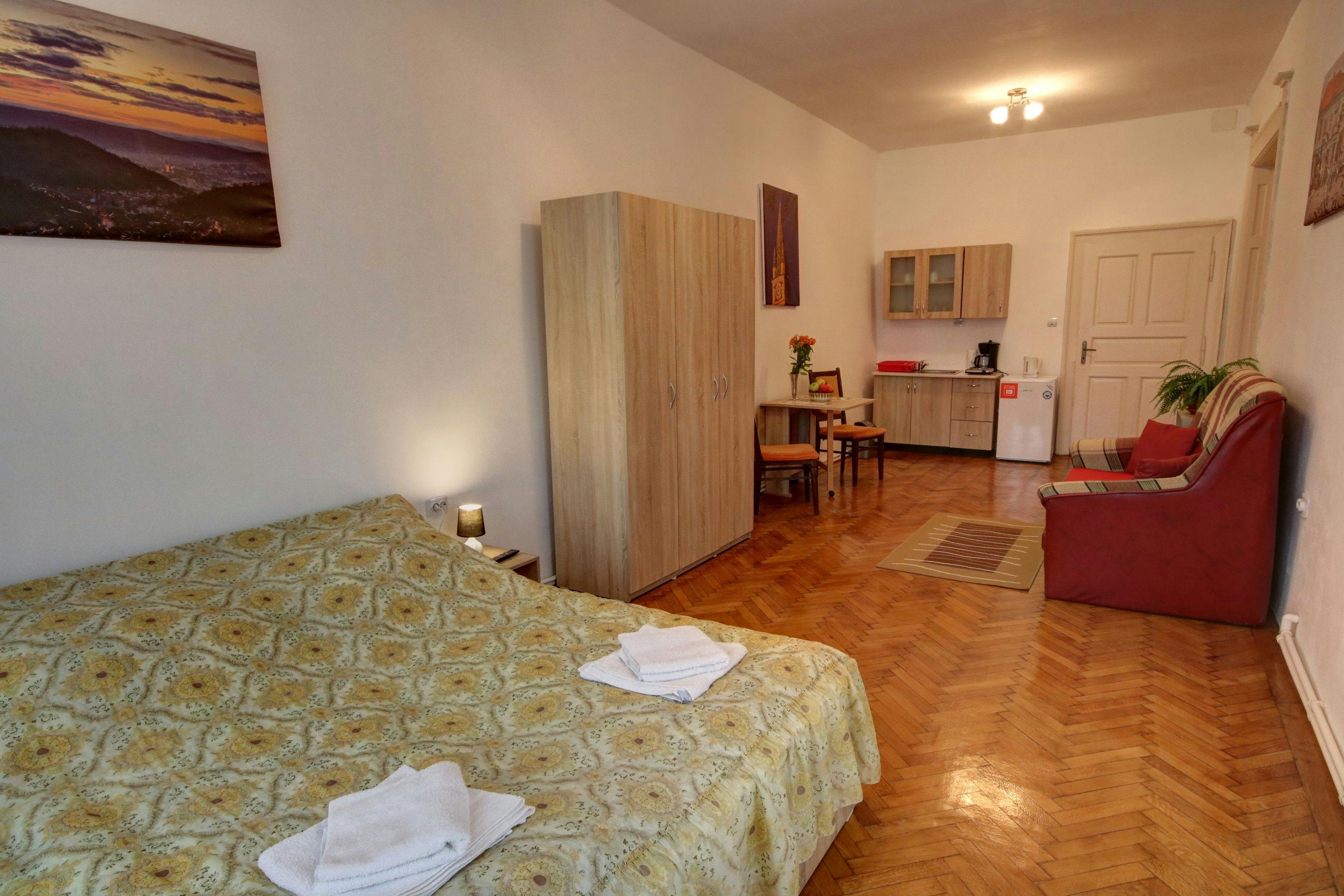 Prosoape proaspete pe pat în cameră cu canapea extensibilă