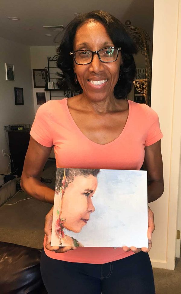 Mamie Duncan-Gibbs holding a small painted portrait of a child.