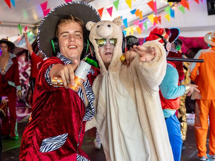 Twee verklede gasten poseren met silent disco koptelefoons op