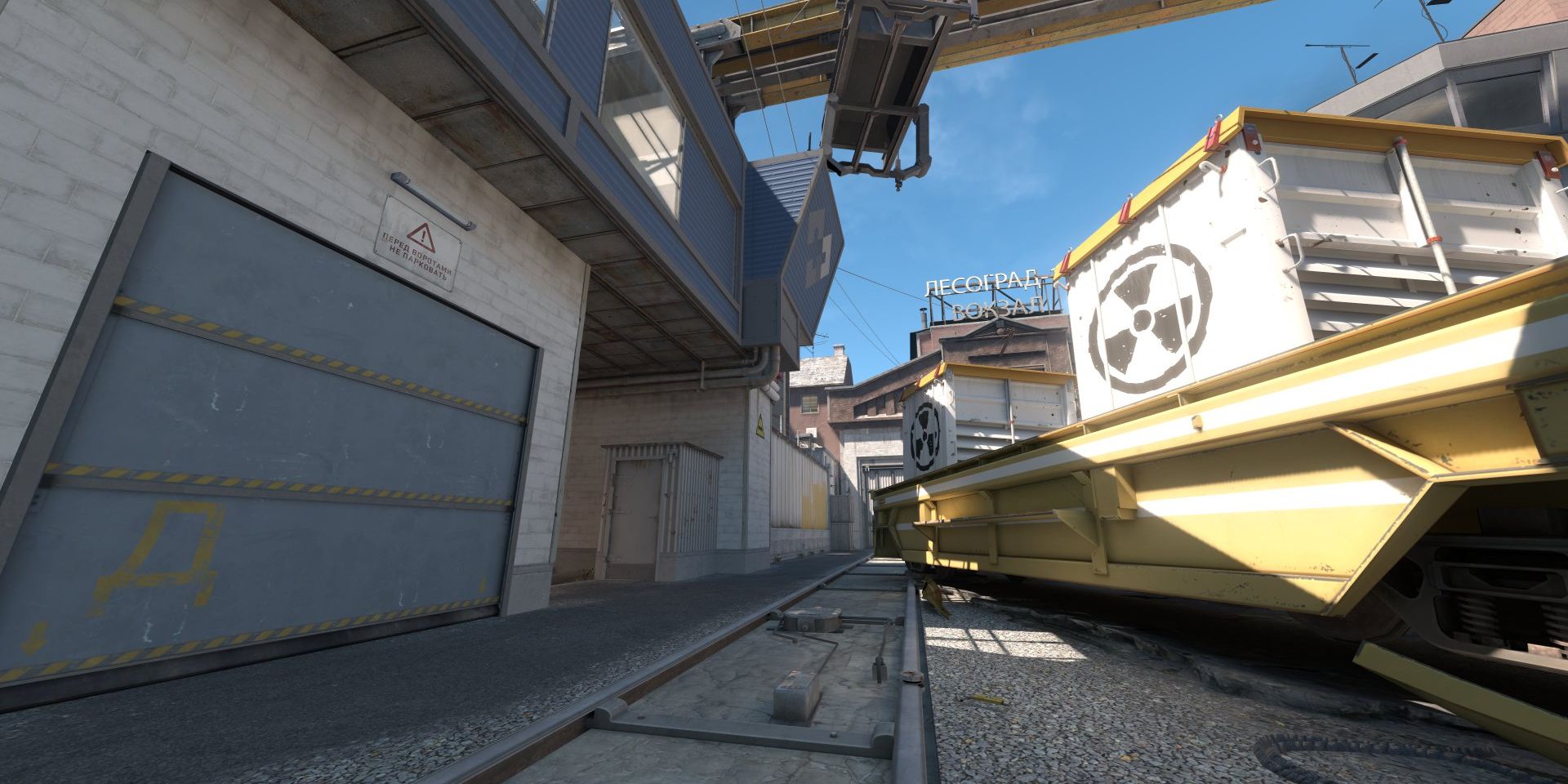 a train is going down the tracks next to a building .