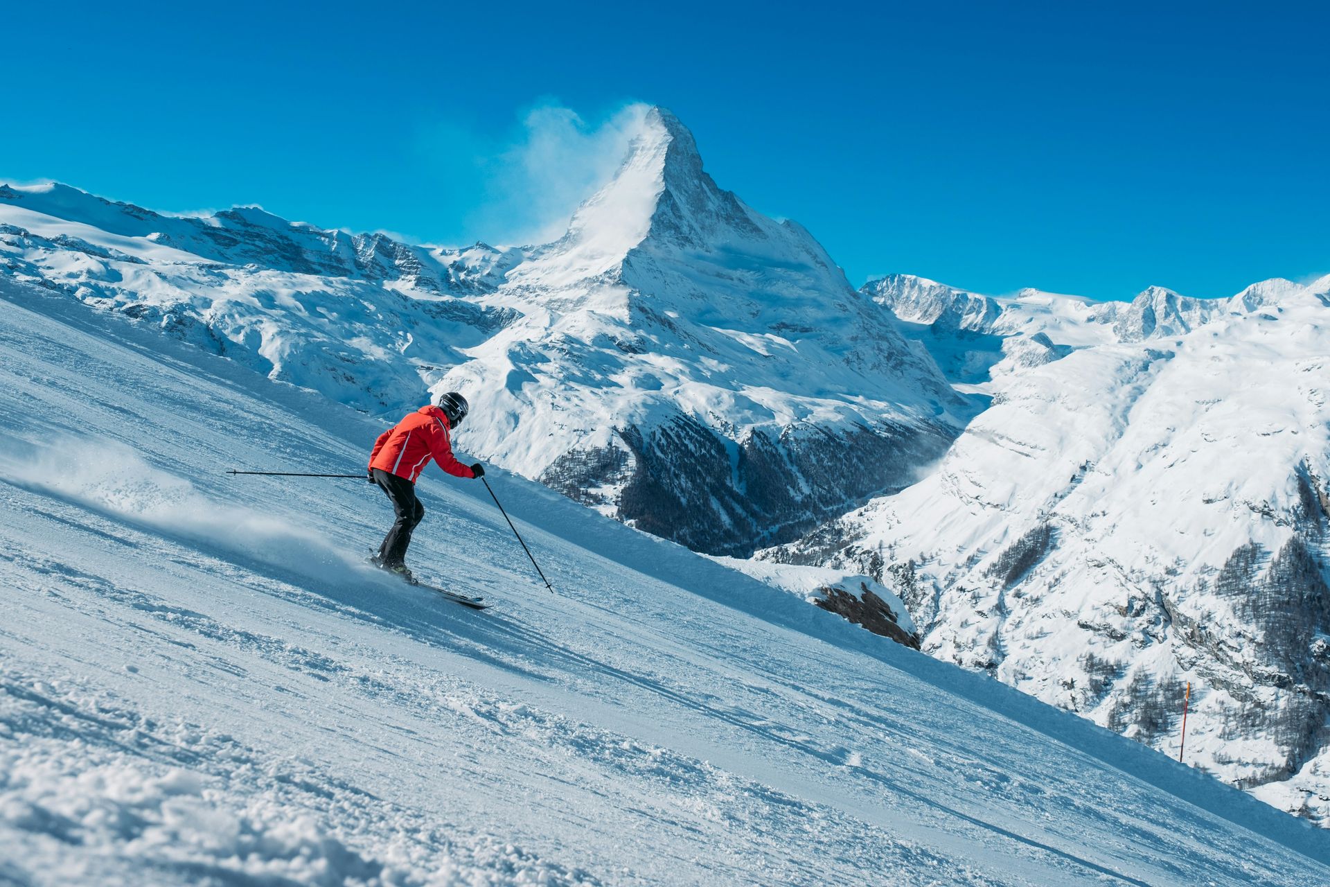 Foto von <a href="https://unsplash.com/@teapowered?utm_source=unsplash&utm_medium=referral&utm_content=creditCopyText">Patrick Robert Doyle</a> auf <a href="https://unsplash.com/photos/a-skier-going-down-a-slope-IvHZn4flNbc?utm_source=unsplash&utm_medium=referral&utm_content=creditCopyText">Unsplash</a>.