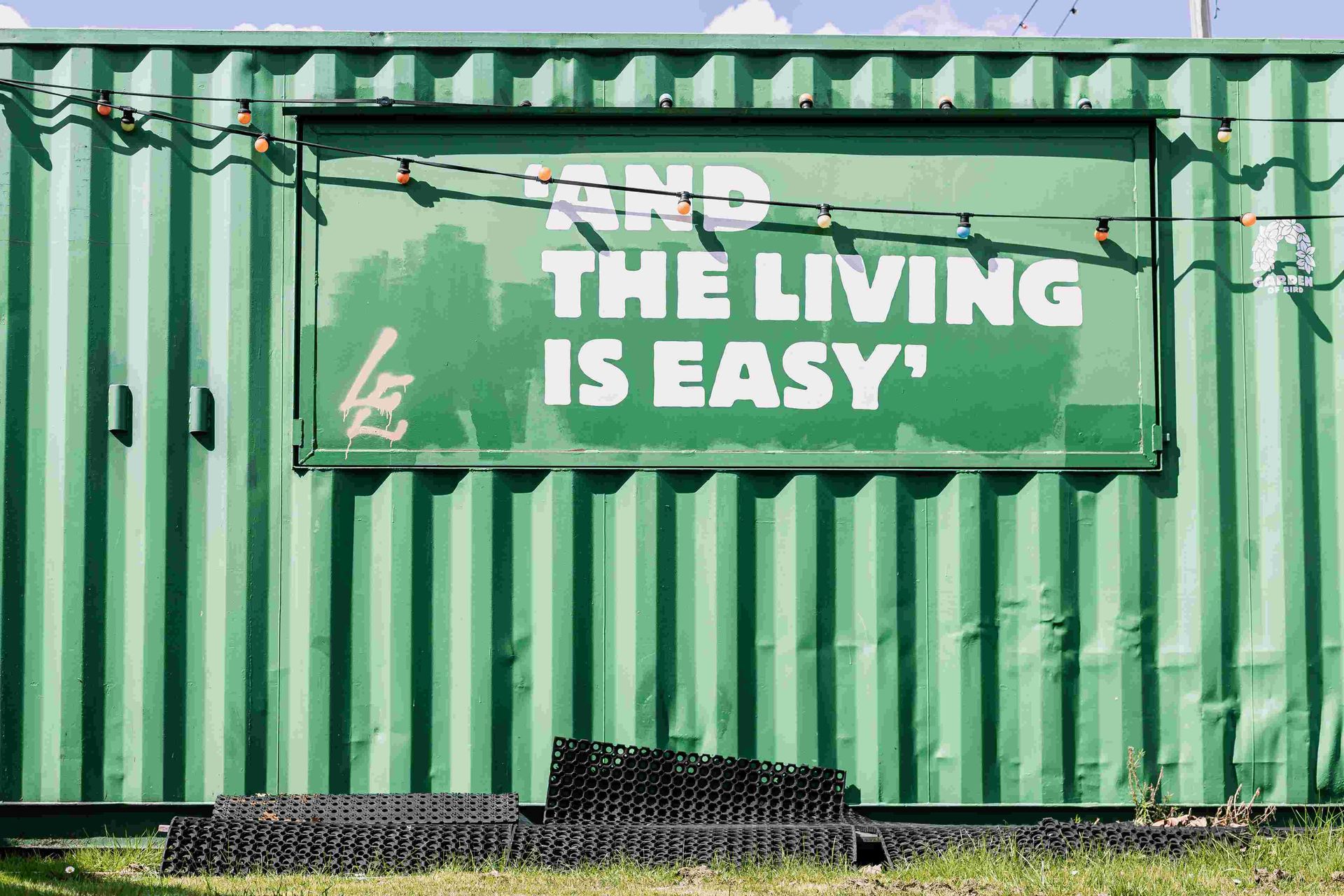 Hier sieht man ein Schild auf einem Container, auf welchem steht: And the living is easy.