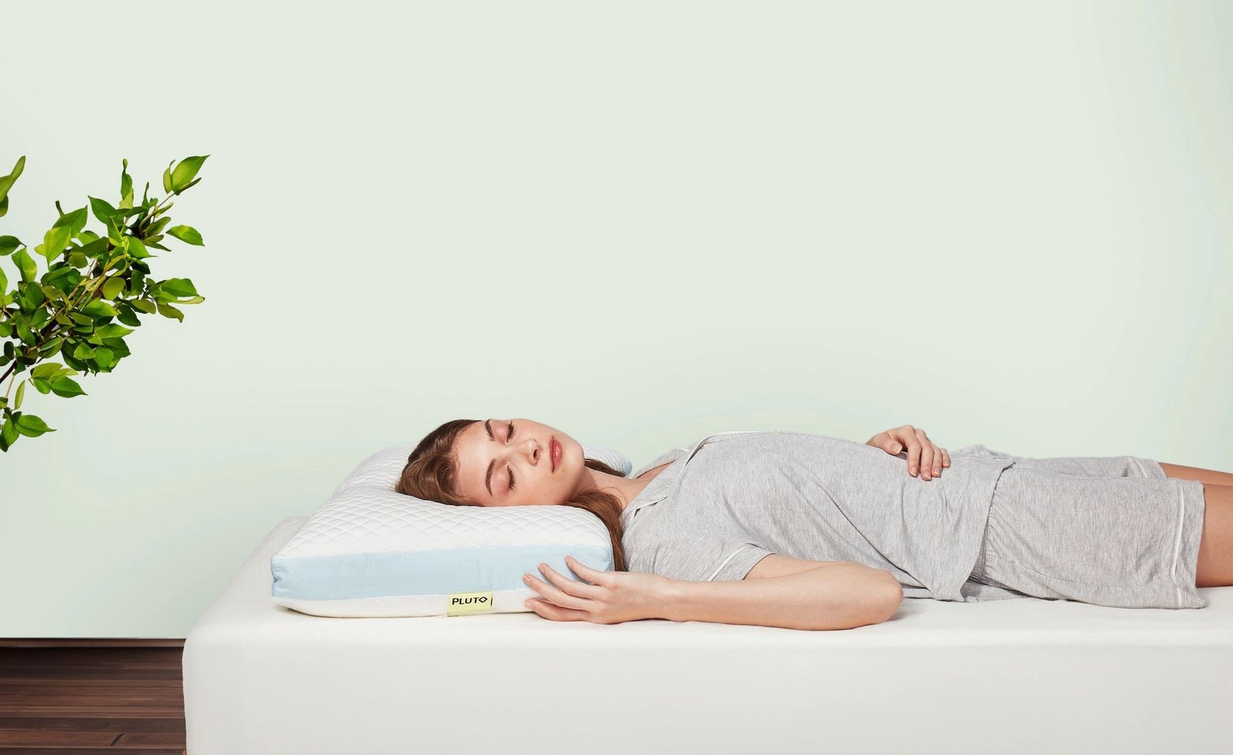 A woman peacefully sleeping on a Pluto pillow.