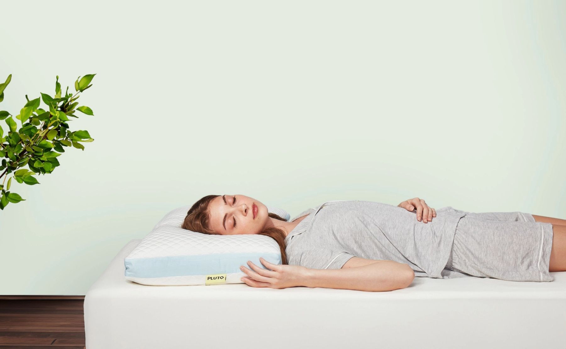 A woman peacefully sleeping on a Pluto pillow.