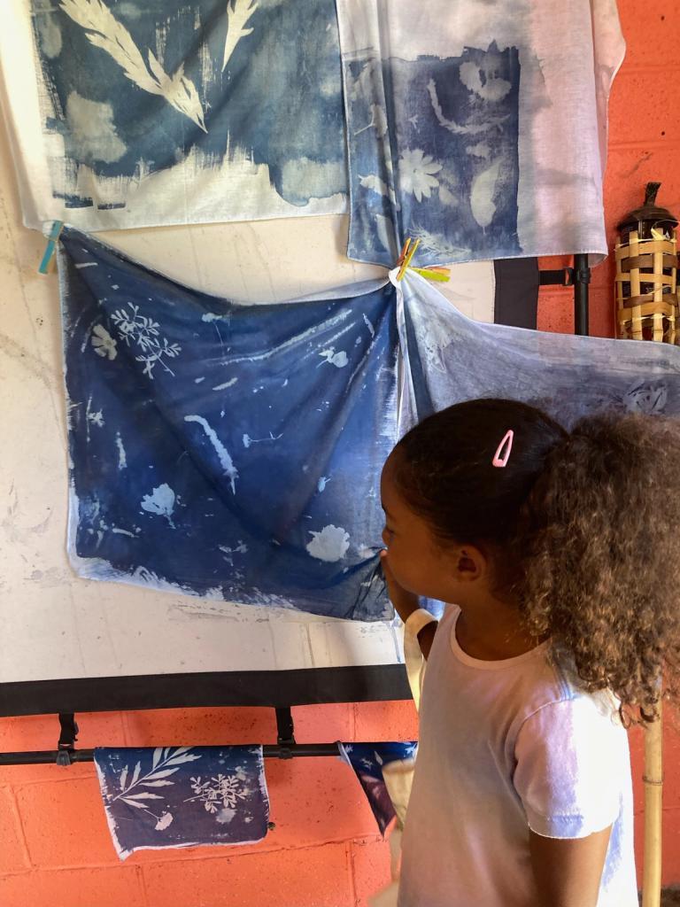 child looking at a blue cyanotype bandana