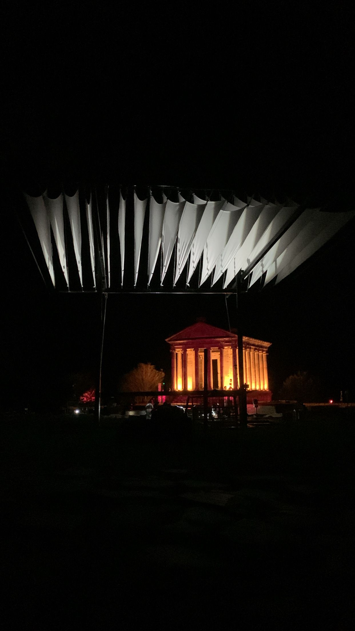 Custom-built black steel DJ canopy with white fabric shade panels, covering a DJ setup at an outdoor festival in the Armenian mountains.